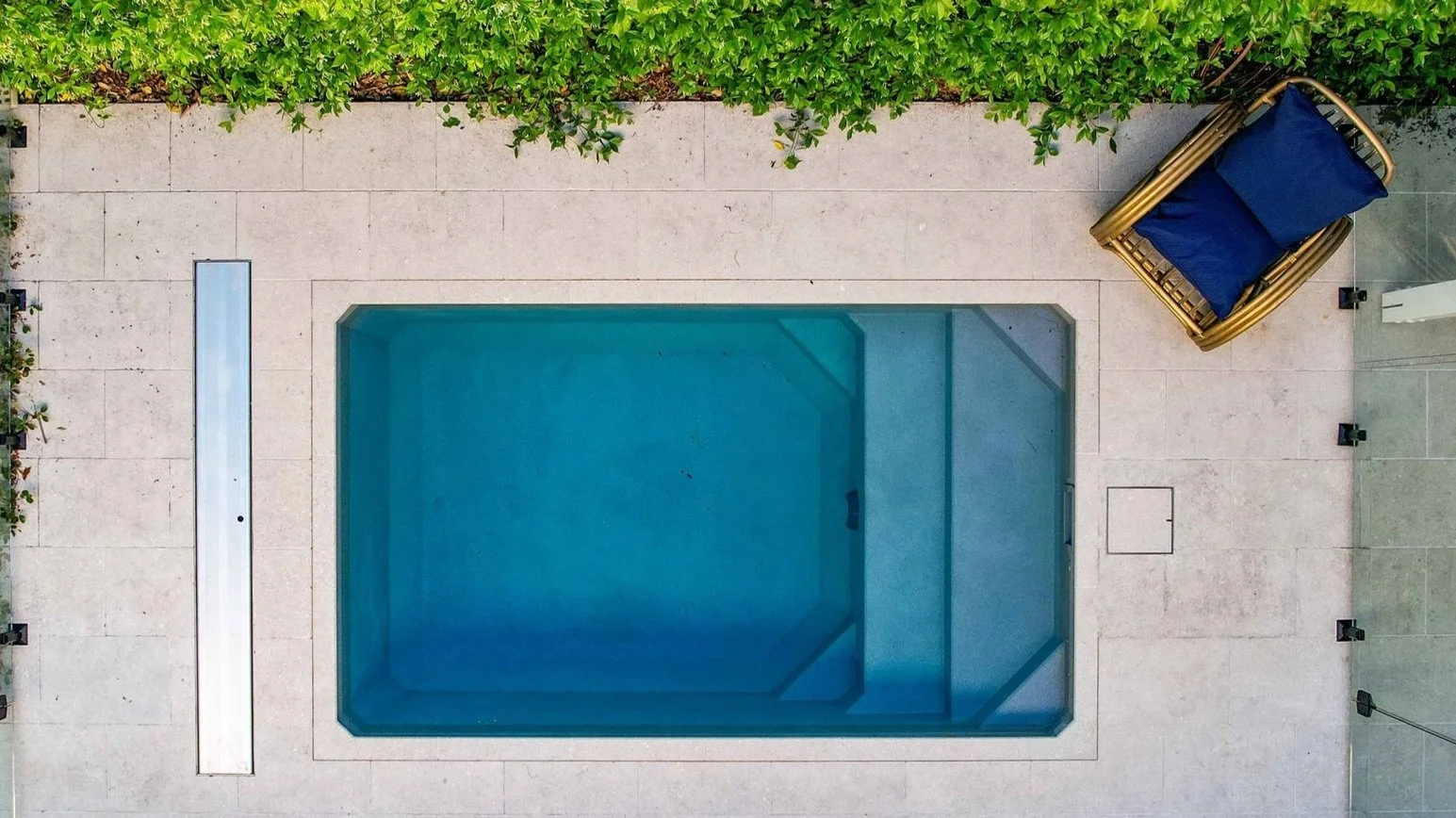 Overhead view of a compact plunge pool with poolside lounge seating