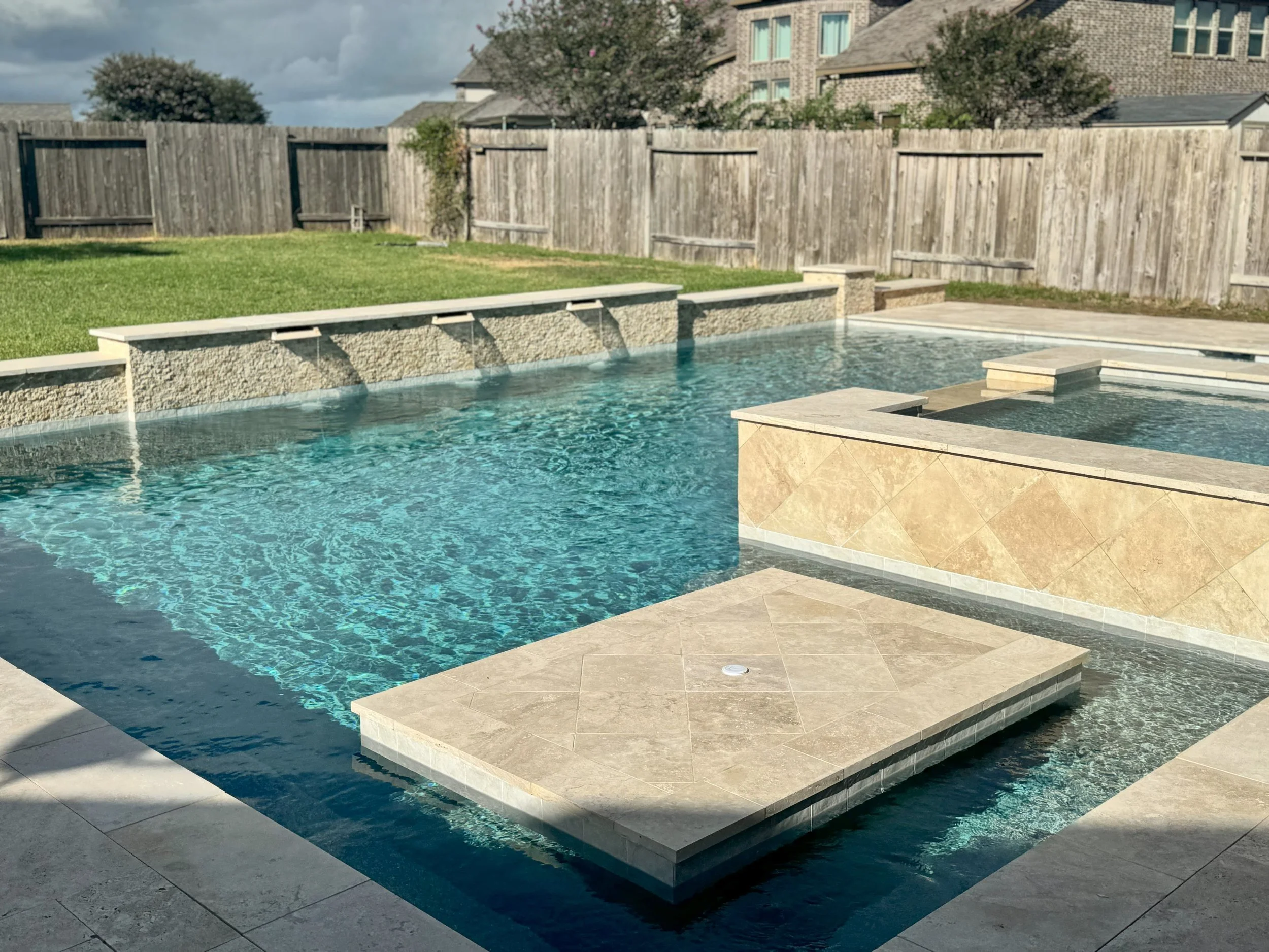 Gorgeous swimming pool with travertine decking, margarita table, in Willow Creek Farms