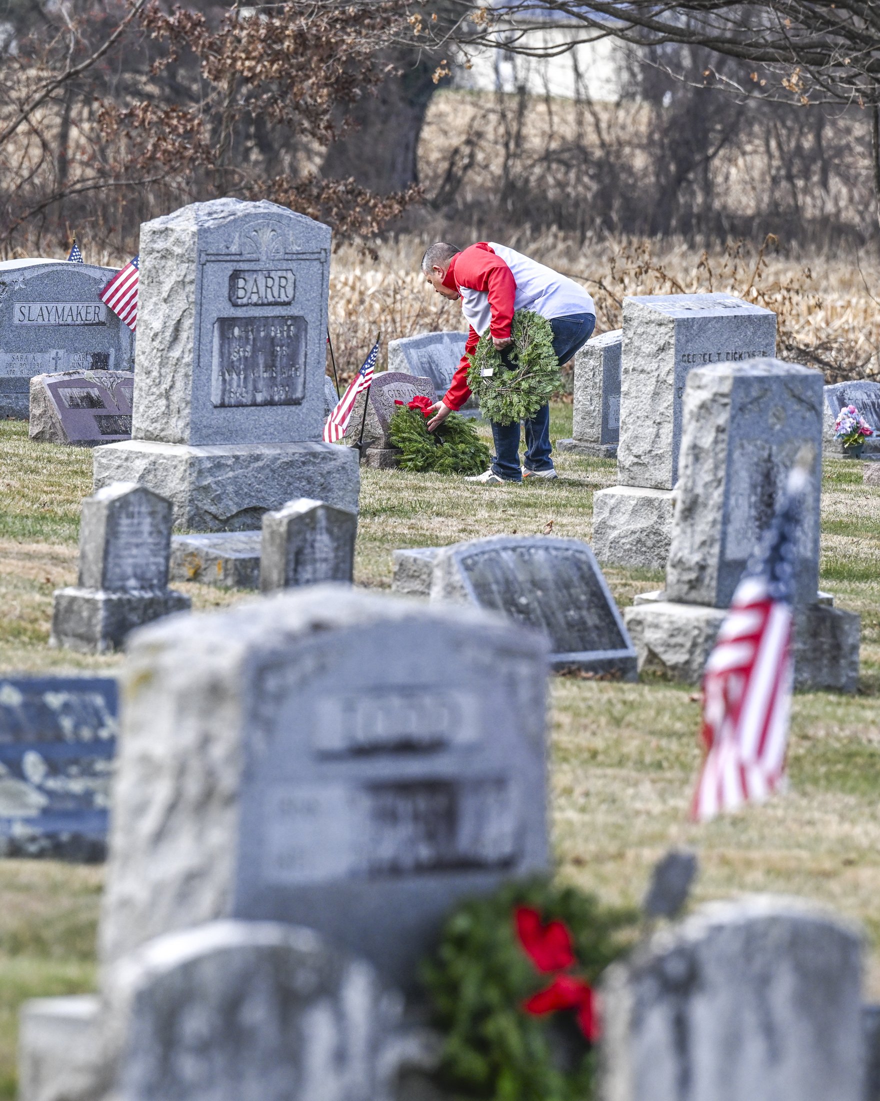 A volunteer lays a wreath on the grave of a veteran at Bellevue Presbyterian Church.