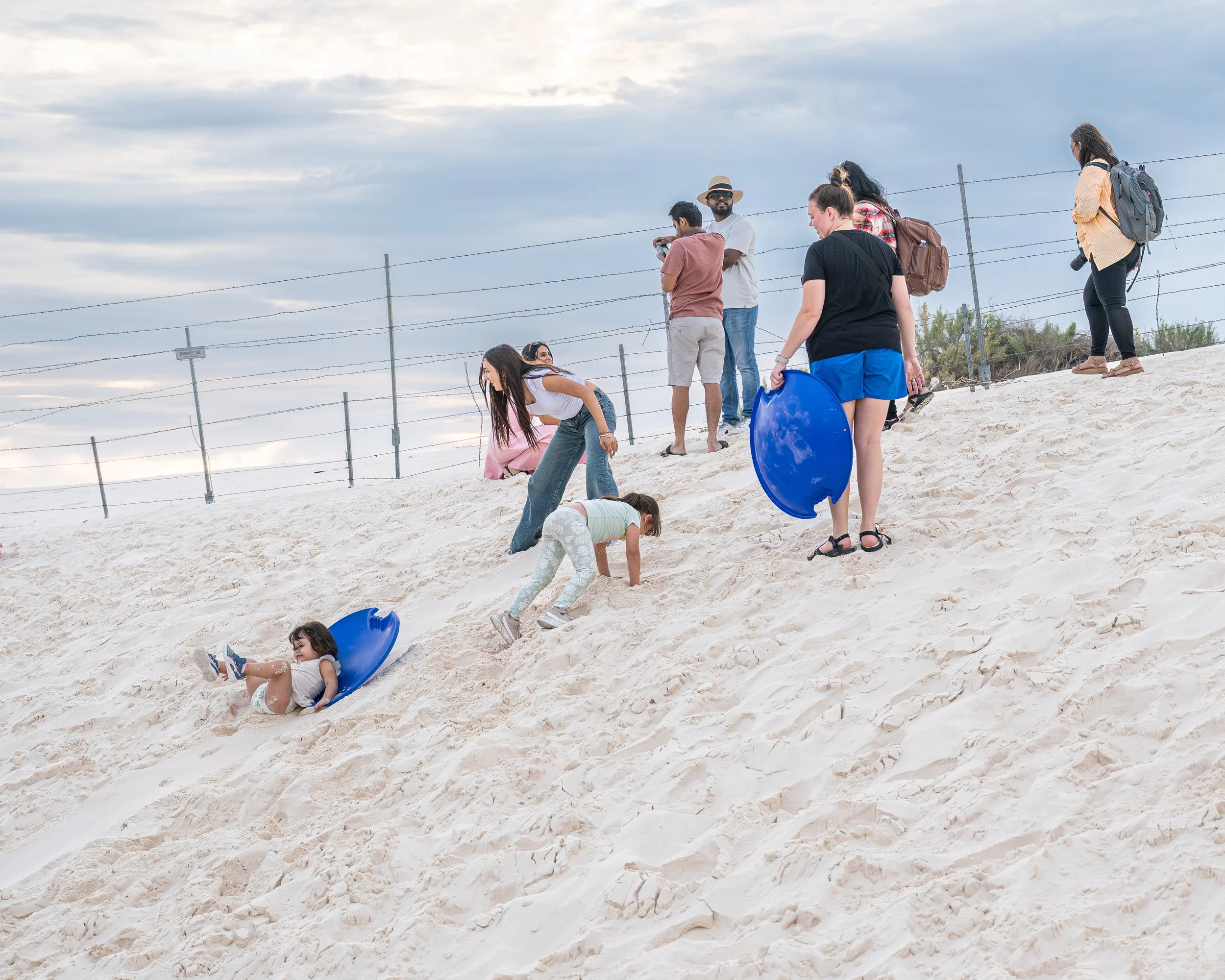 Families sledding on gypsum dunes at White Sands National Park