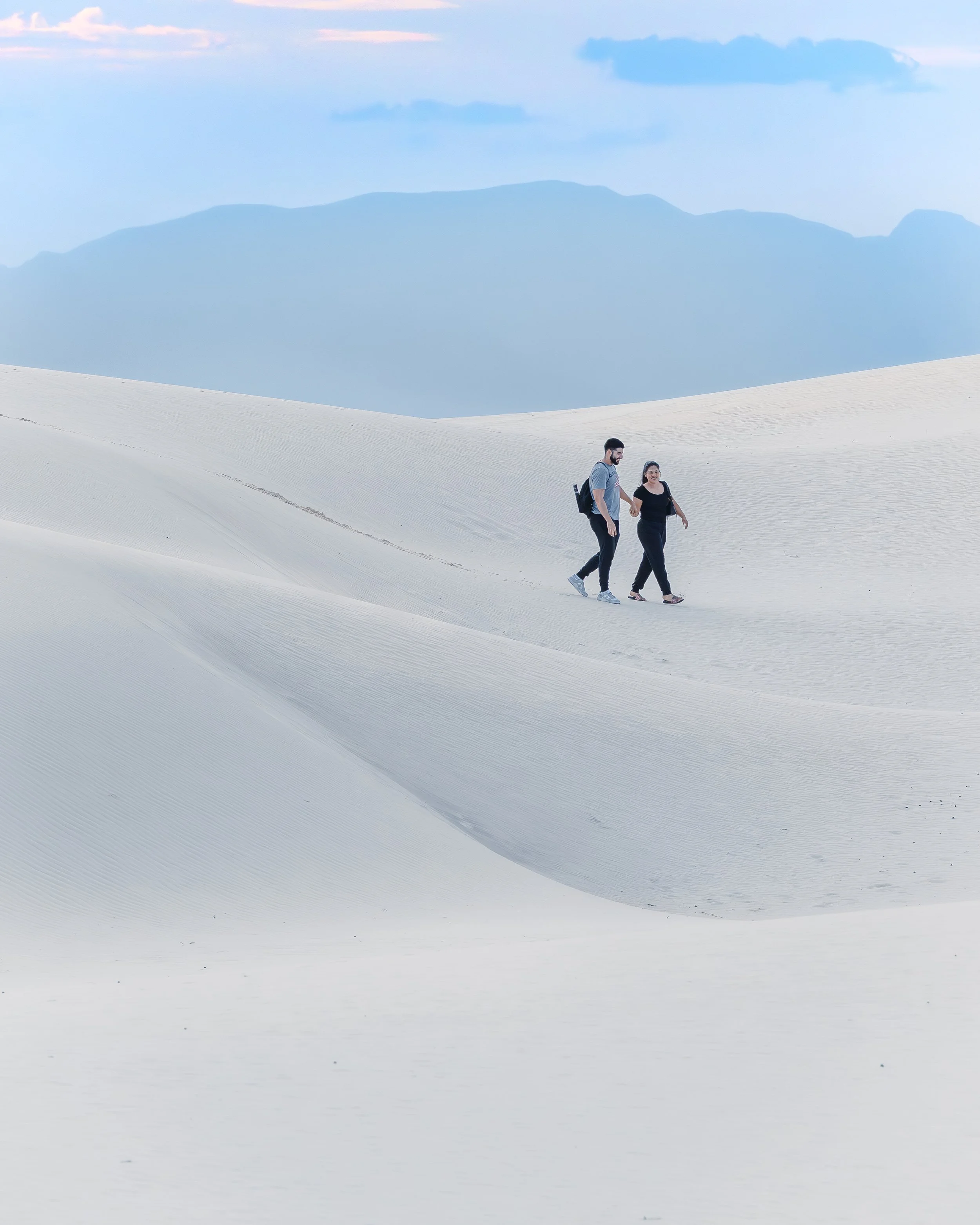 A couple explores the dunes at sunset