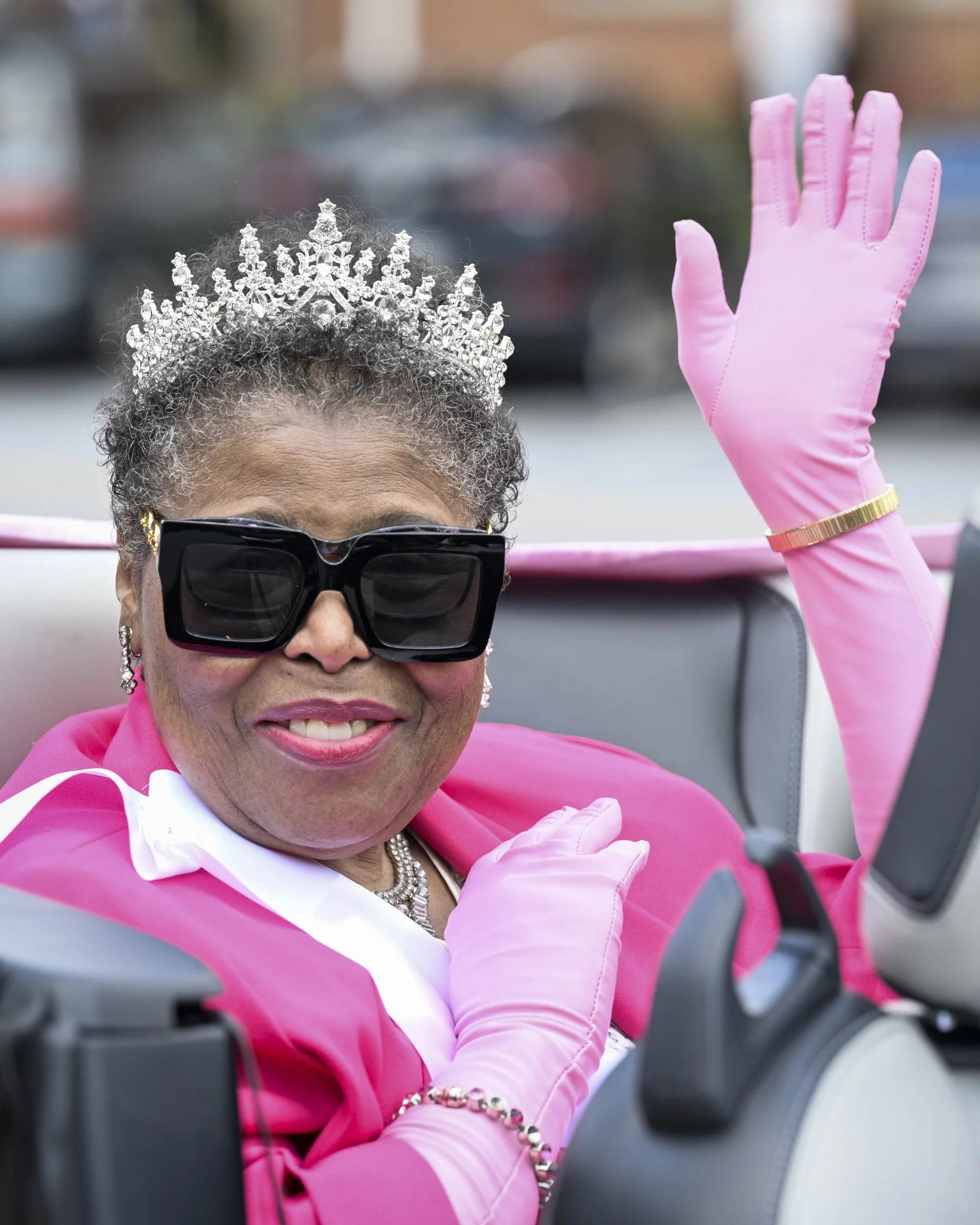 Karen G Dixon, of Lancaster, PA, winner of the Fun Pink Pageant, waves from her parade car.