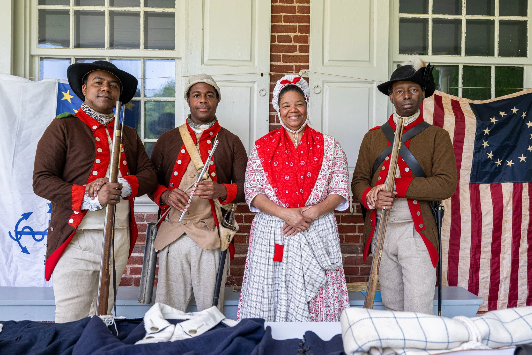 Nick Guzman, of Ewing, New Jersey; Steve Thomas, of Pennsville, New Jersey; Leslie Bramlett, of Trenton, New Jersey; and Antoine Watts, of Lansdowne, Pennsylvania, display their historically accurate uniforms during Rock Ford America250 Family Day on
