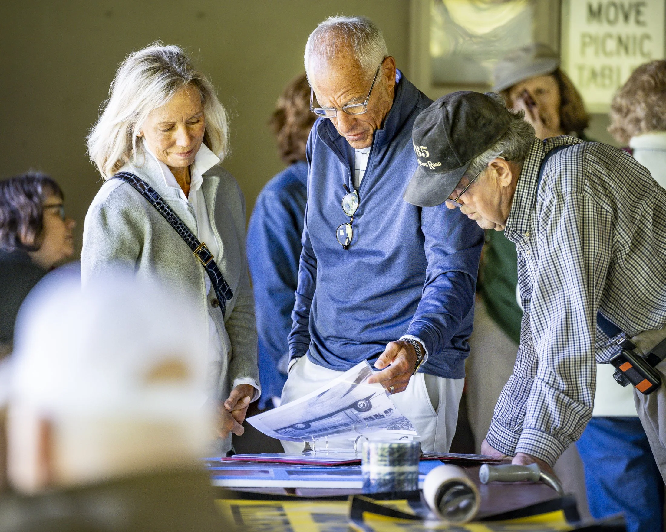 Dan Herr, son of John Herr, and his wife Tina Jobes look at historical photos of his father and his store during the John Herr plaque unveiling in Freedom Memorial Park on Memorial Day, Monday, May 26, 2025.