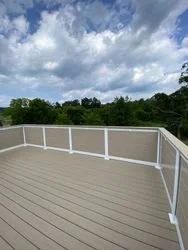 Straight deck boards and evenly spaced privacy railing with drink rail top