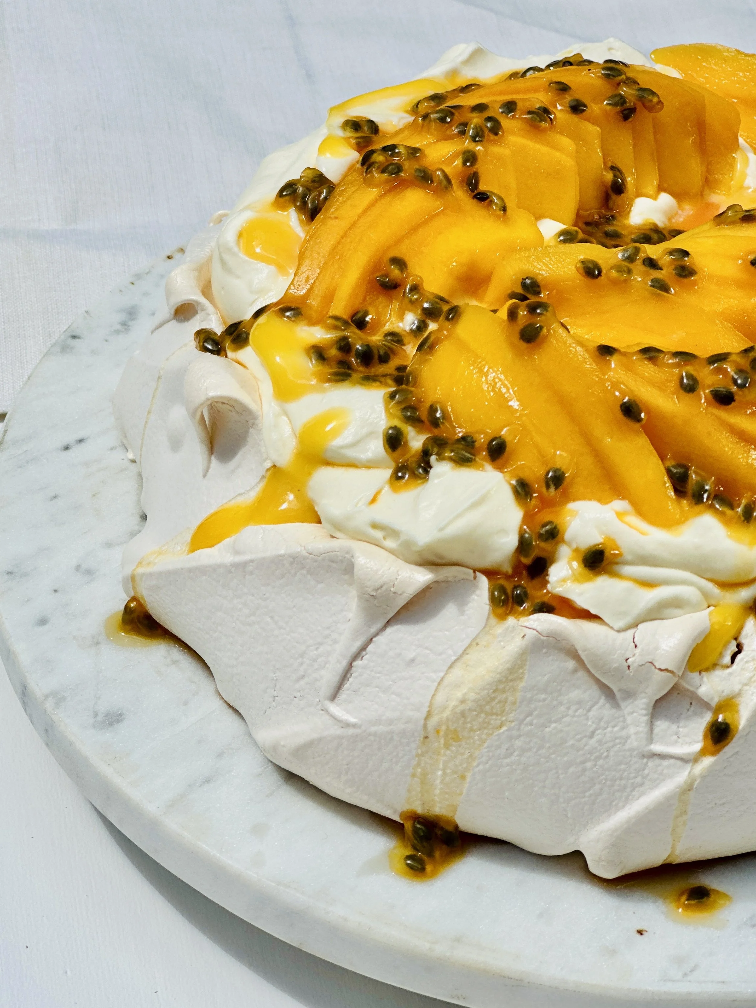 PAVLOVA TOPPED WITH LEMON CURD CREAM, MANGO AND PASSIONFRUIT