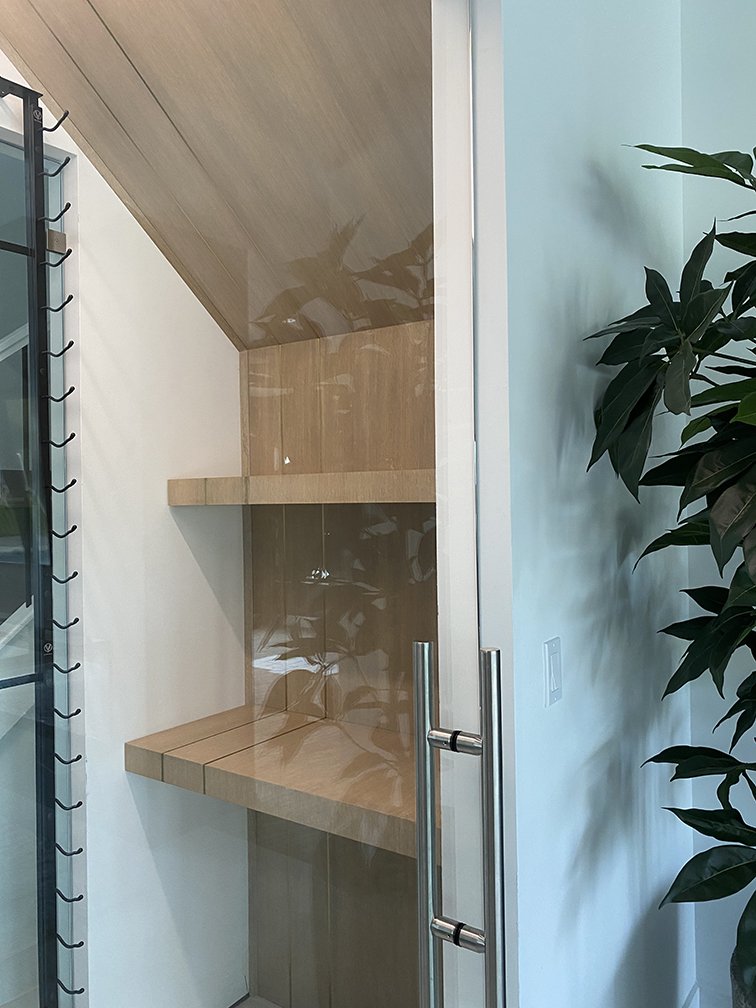 Wine closet with wraparound oak shelving, double inlaid brass strips. Design by Timeless Oak Designs