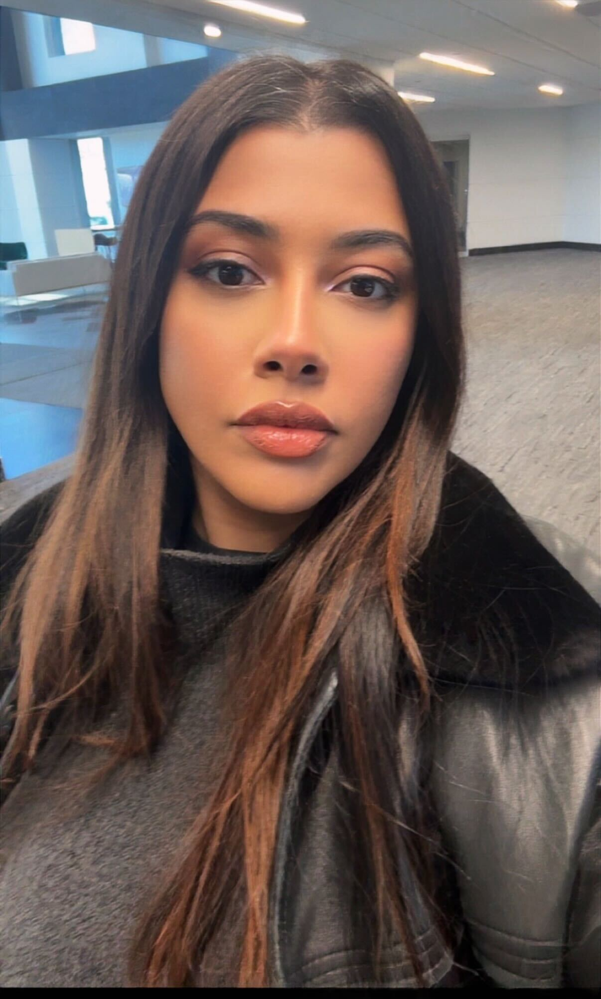 A young lady wearing black in an office background. 