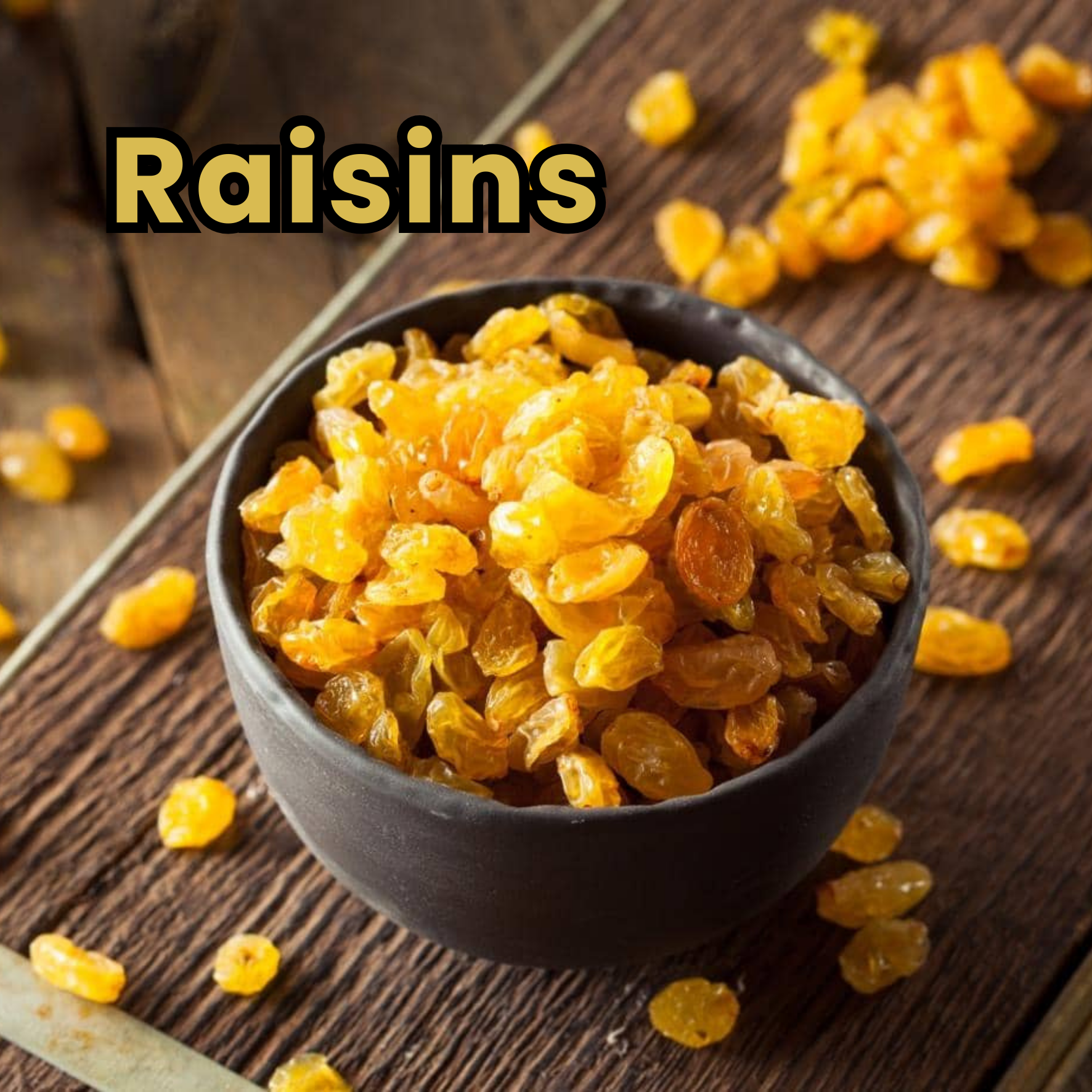 A black bowl filled with golden raisins placed on a wooden surface with loose raisins scattered around it.