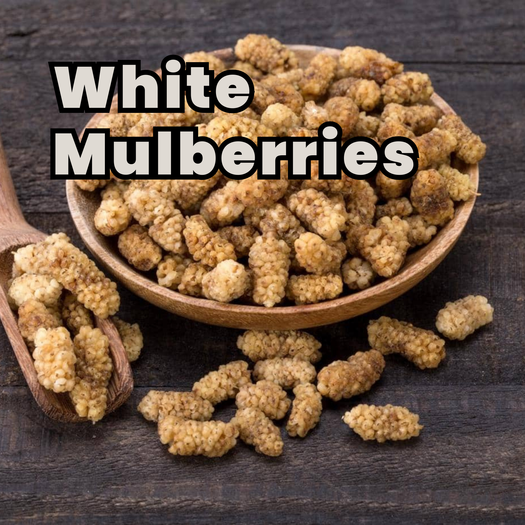 Group of white mulberries in a wooden bowl and on a dark wooden surface with some spilling out.