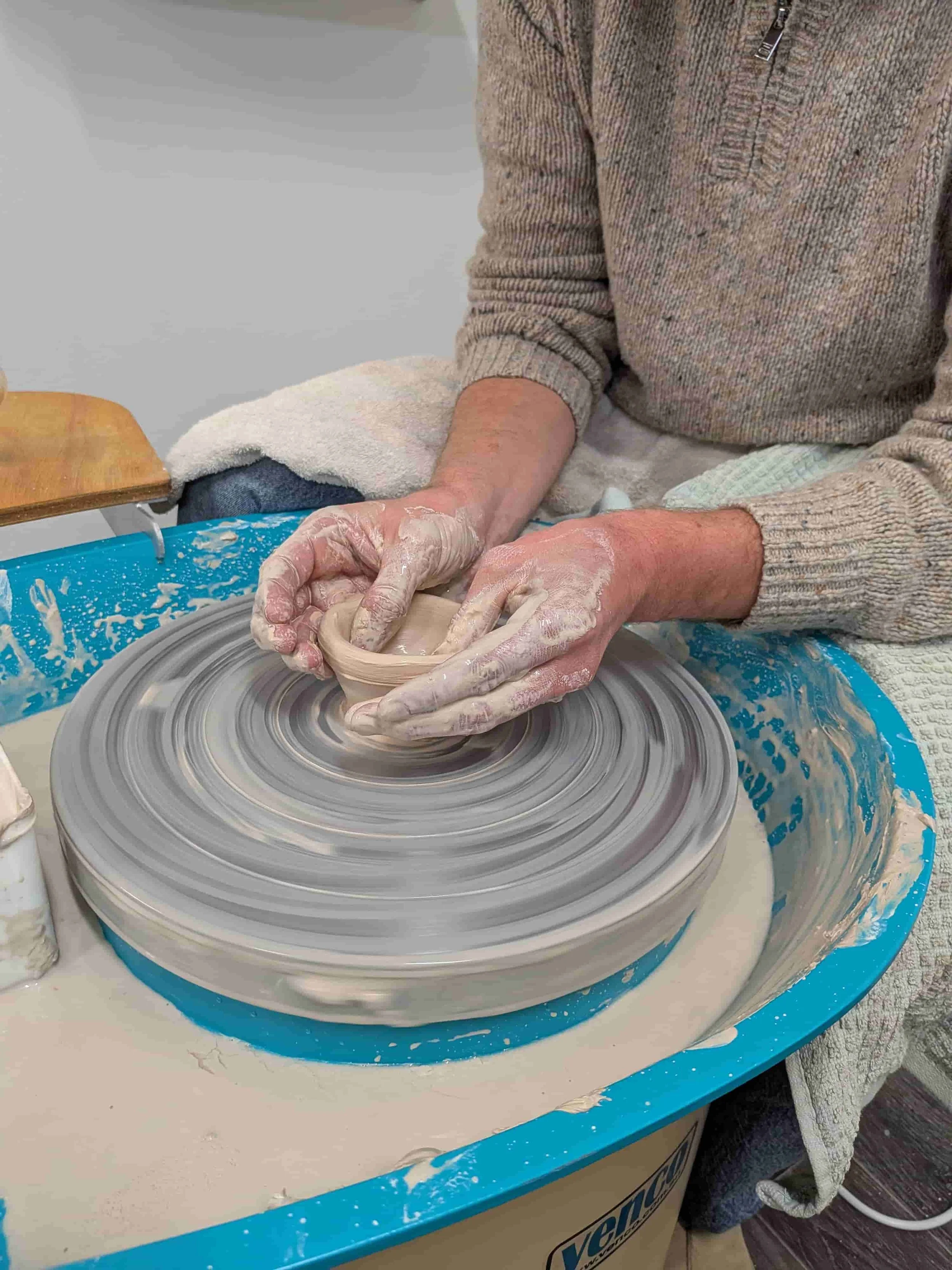 Student learning wheel throwing during a pottery class at From Dust Studio in Perth