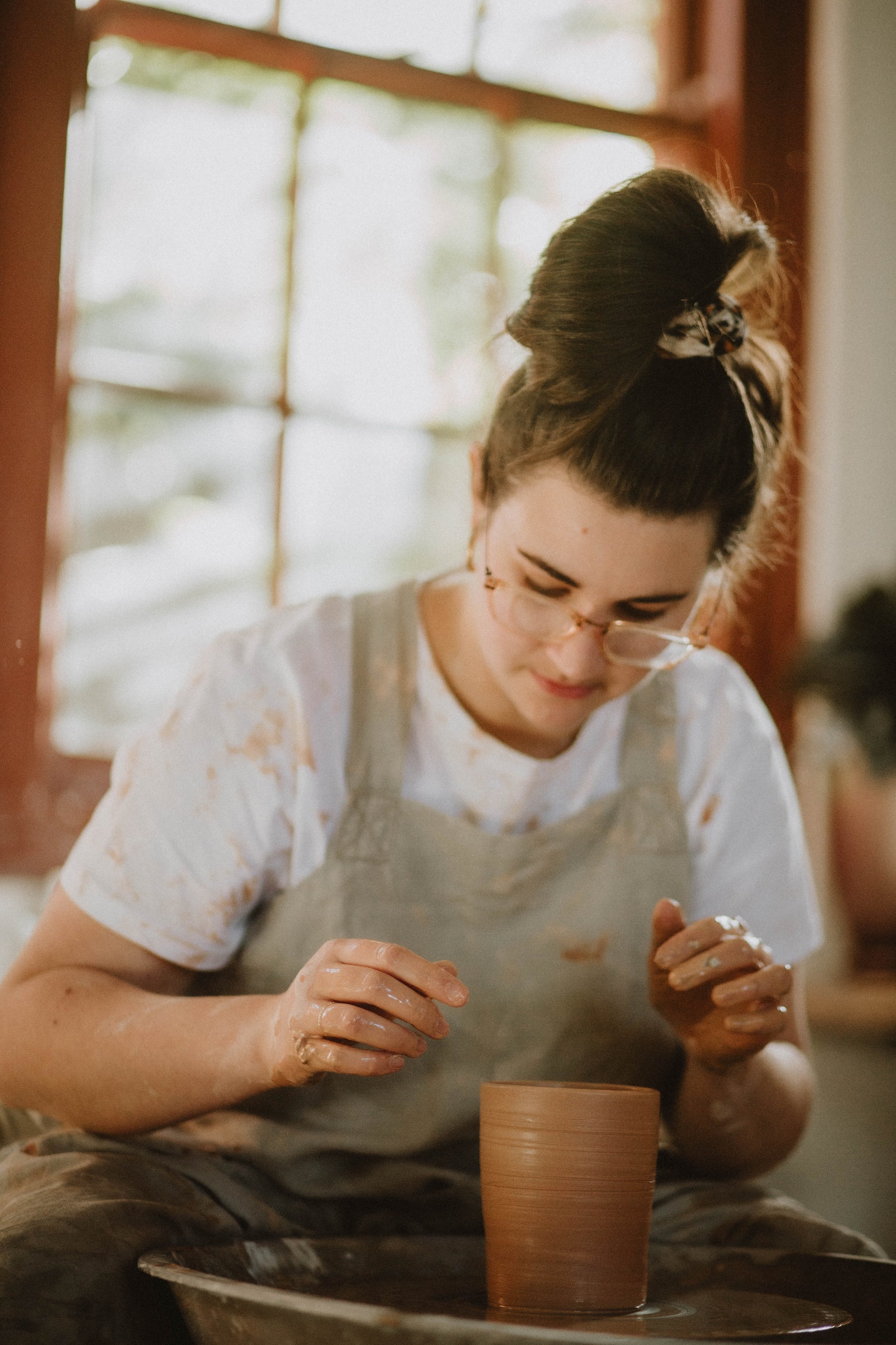 Person shaping clay on a pottery wheel during a beginner pottery class at from dust studio in Perth