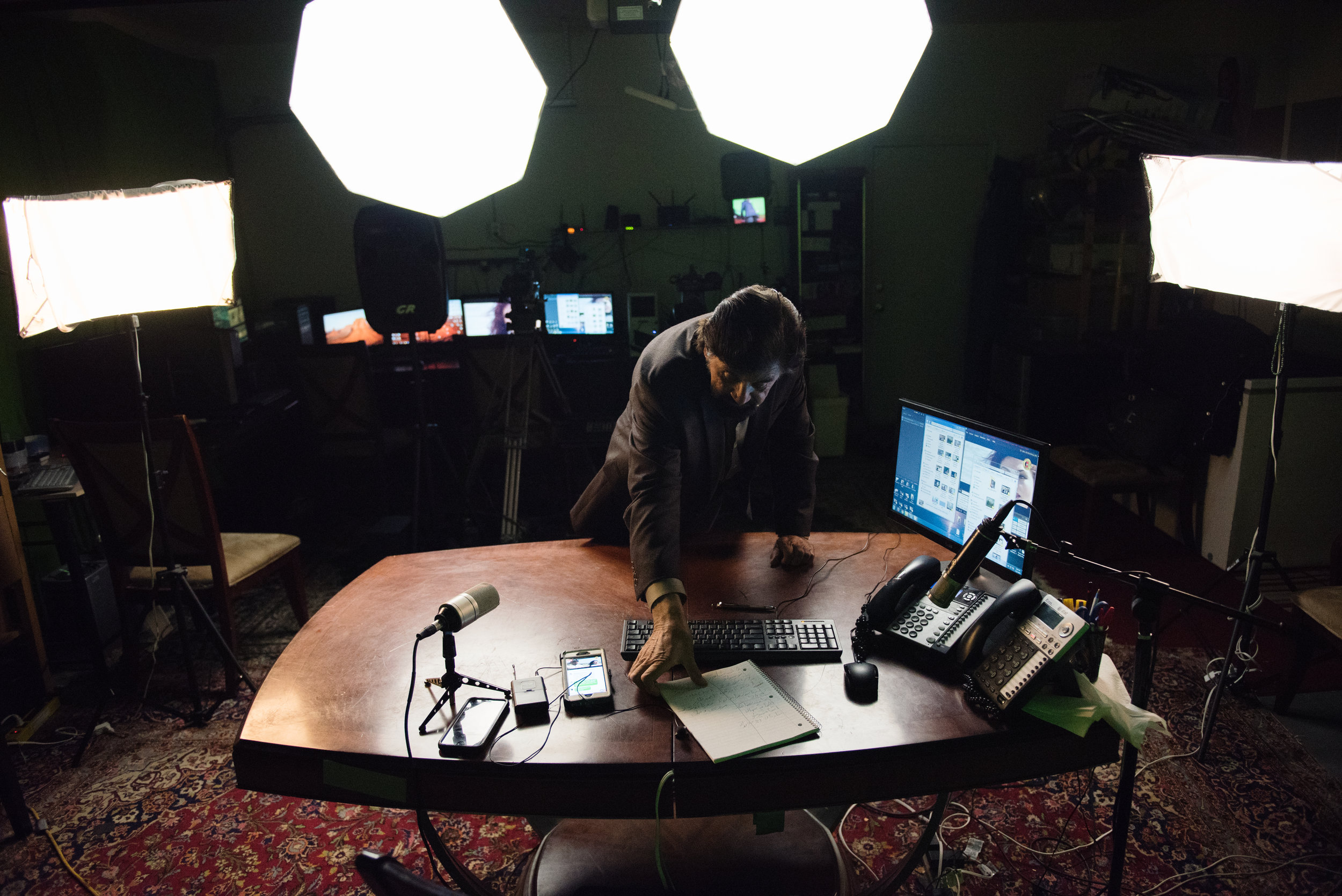  Haroon Ebrat rearranges his desk during an intermission in his Afghan variety show, filmed live in the garage of his family home in Pittsburg, California, on Sunday, February 11 2017. | Rosa Furneaux for Pacific Standard Magazine 