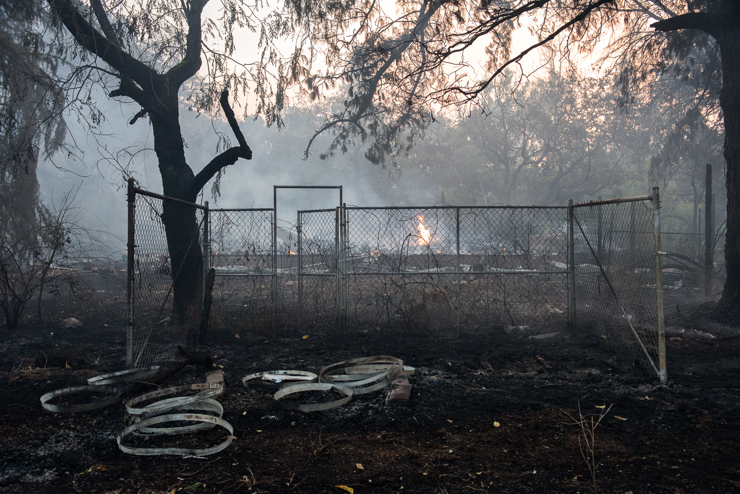  The remains of a burned house smoulder on the morning of Saturday, 14 October 2017, as the sun rises on Sonoma during the devastating North Bay wildfires. 