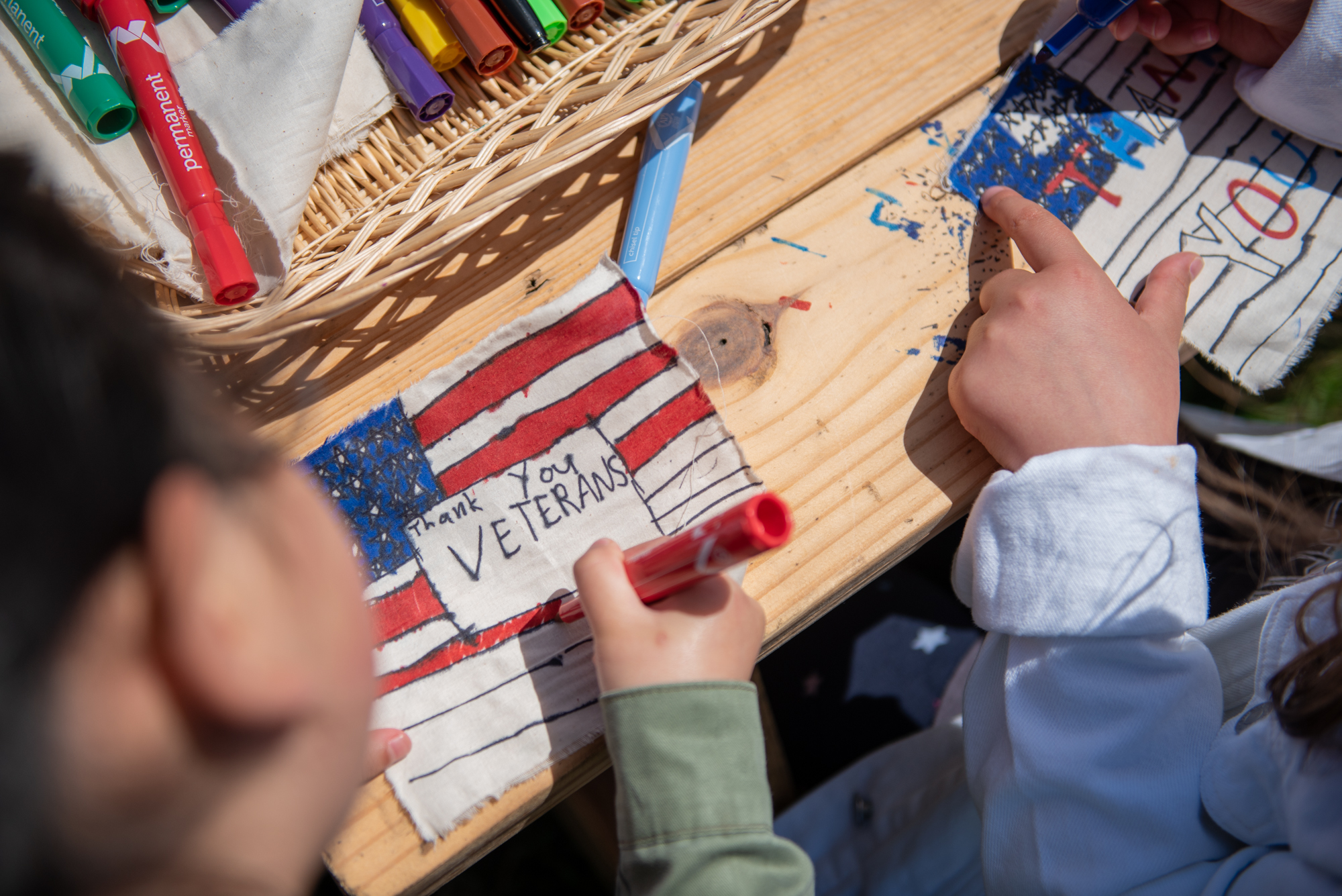  Addison Kim, 7, and Sophie Philhour, 8, decorate their flags for the Presidio Trust’s Civilian Veteran Flag Collage on Sunday, May 27, 2018. | Rosa Furneaux, Special To The Chronicle 