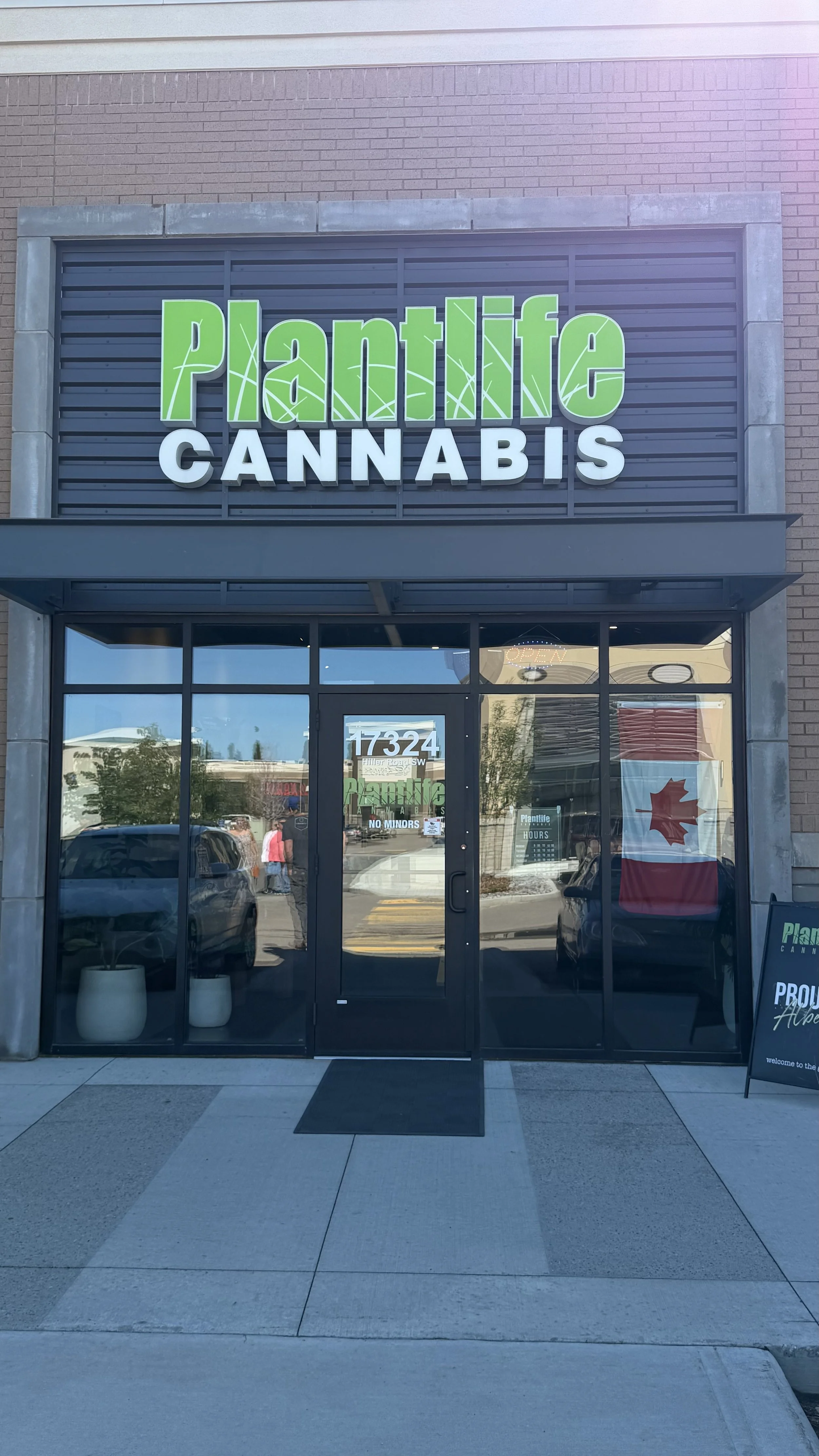 storefront of Plantlife Cannabis with a sign above the door and a Canadian flag in the window. Complete Electrical Services completed by Genstar Electrical Constructors Ltd.