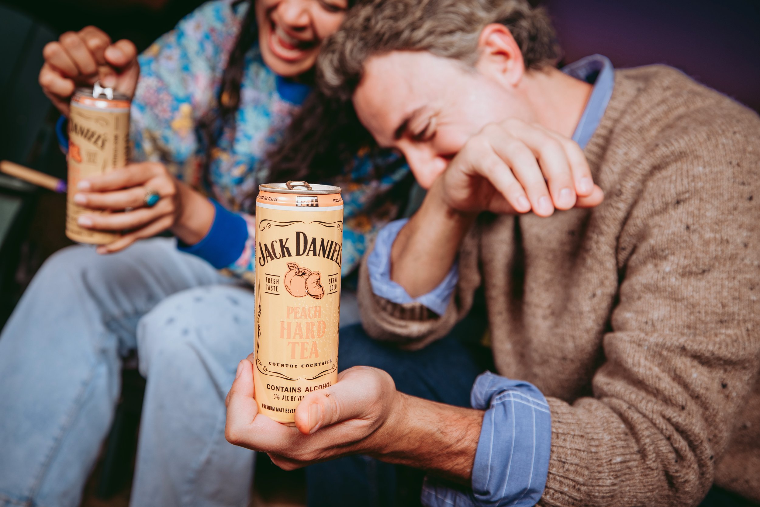 Commercial lifestyle beverage and food product photography featuring Gen Z and millennial talent in an outdoor social setting, capturing candid laughter and authentic interaction with natural light to create an eye-catching, high-impact image in atx.