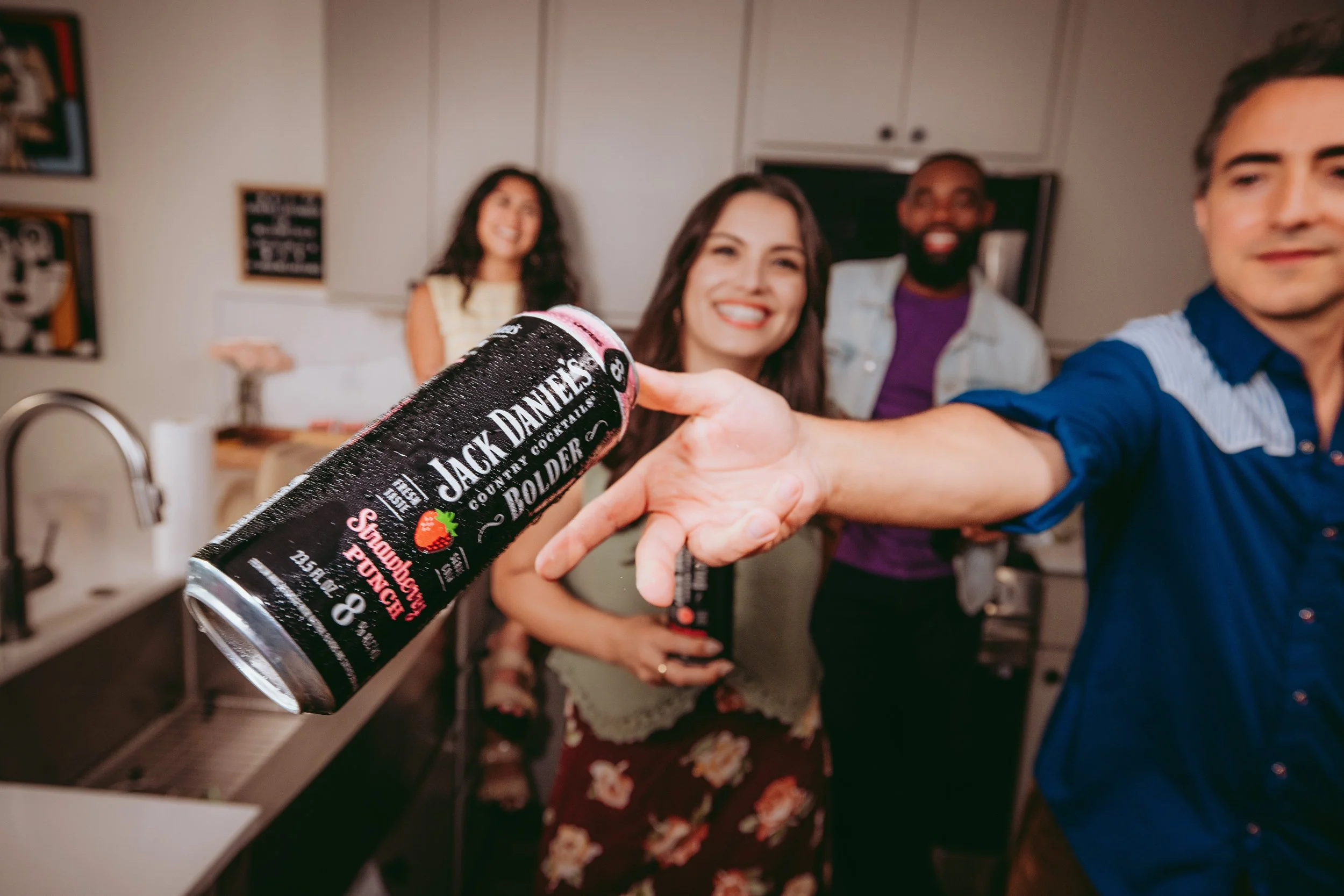 Commercial lifestyle beverage and food product photography featuring Gen Z and millennial talent in a social kitchen setting, using vibrant energy and natural interaction to create an eye-catching, high-impact image for alcohol brands, social media.