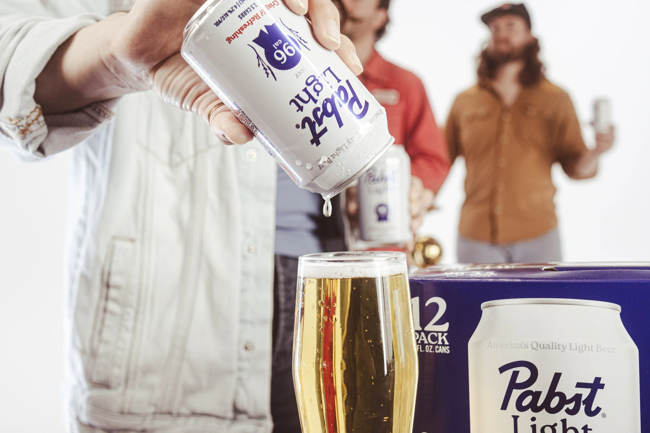 Commercial beverage and food product photography of Pabst Light beer being poured into a glass, with branded packaging in a lifestyle setting for social media and advertising content in Austin, Texas.