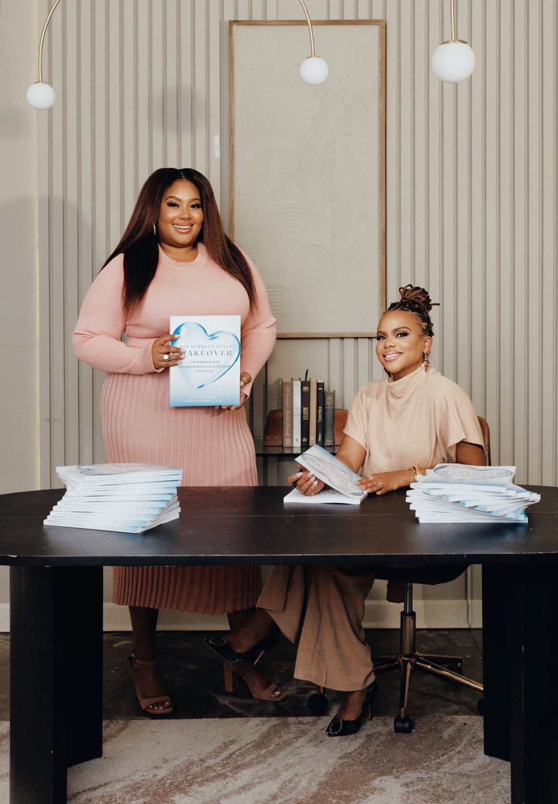 Miranda and Jessica of Therapist Bestie reviewing their published workbook, modeling the visibility and confidence they support therapists in building