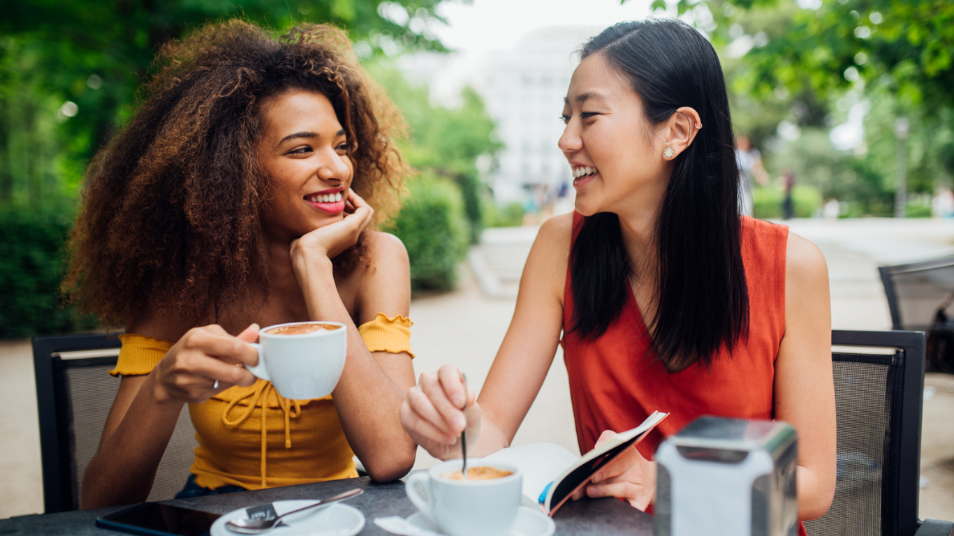 Two women sitting outside having coffee together, representing a supportive and thoughtful next step in working together