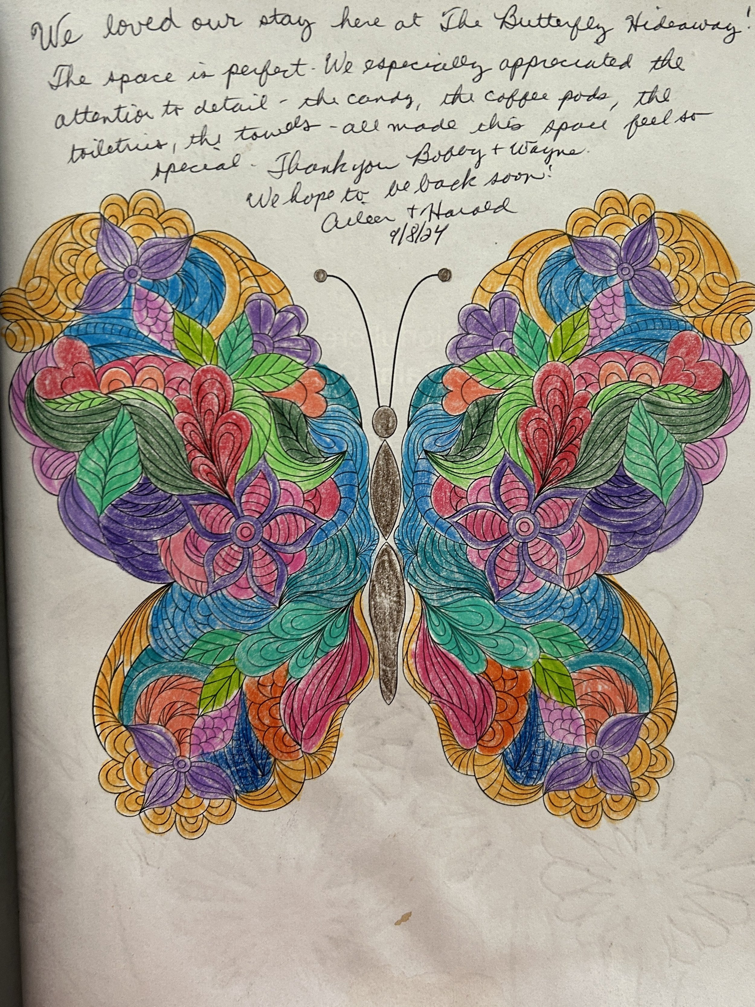 Colorful butterfly with intricate floral and leaf patterns on its wings, drawn and colored with multiple vibrant hues.