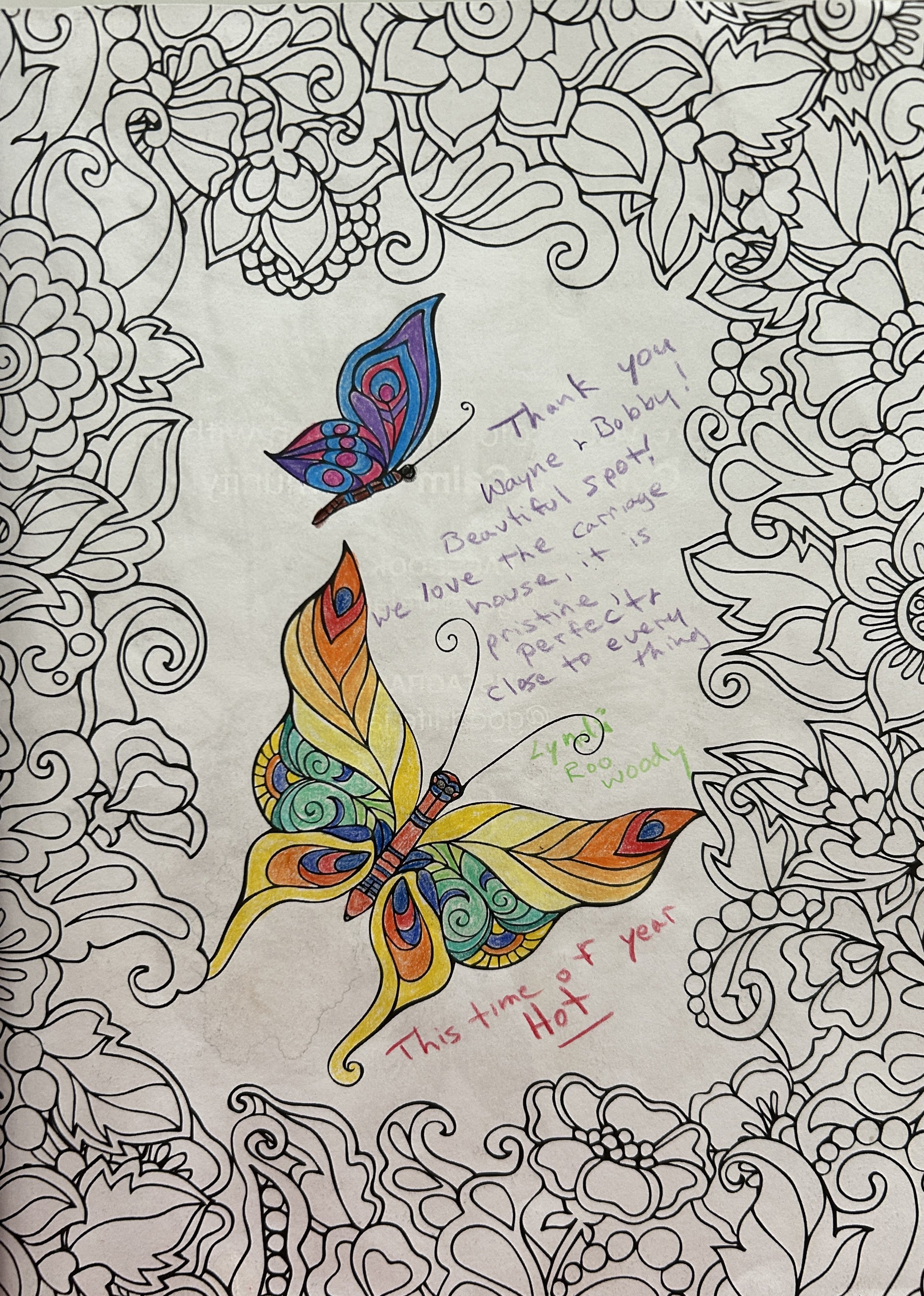 A coloring page featuring intricate floral patterns in black and white, with a colorful butterfly at the center and handwritten notes around it.