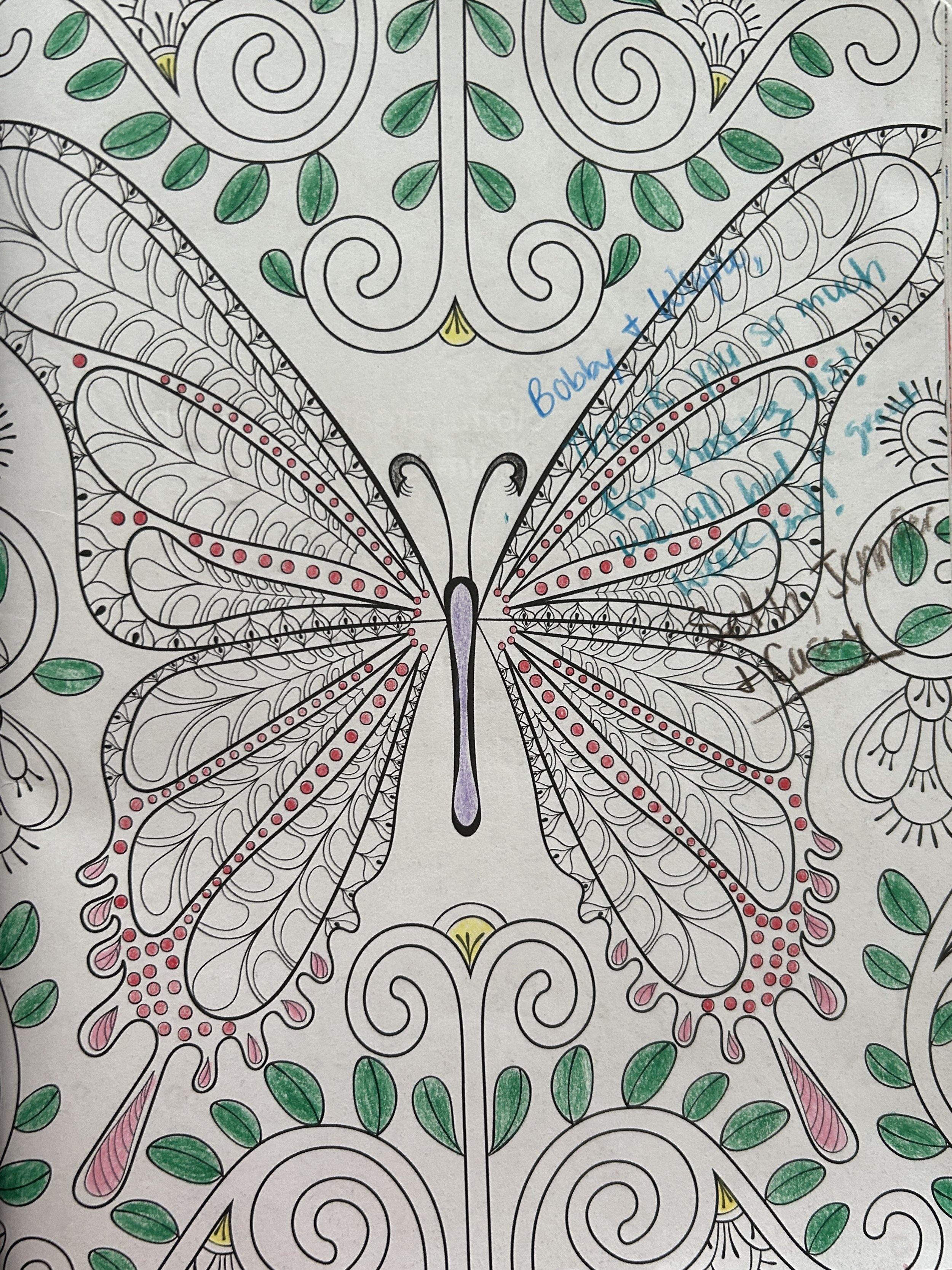 A detailed coloring page featuring a butterfly with symmetrical wings decorated with intricate patterns, swirls, dots, and teardrop shapes, surrounded by additional decorative elements and partial handwritten notes.
