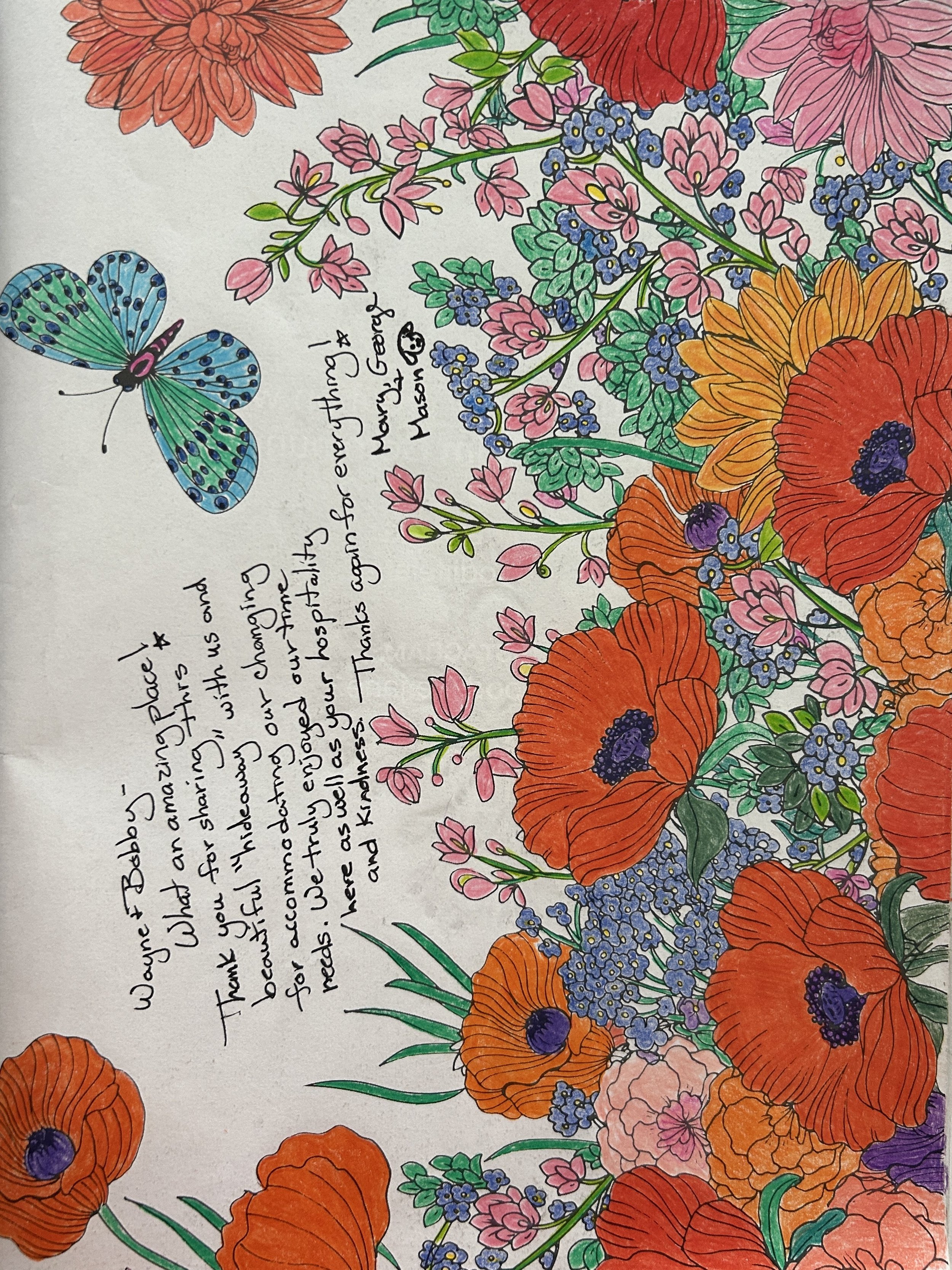 Colorful hand-drawn floral illustration featuring red poppies, pink, purple, and blue flowers, green foliage, and a blue and green butterfly. Handwritten note expressing gratitude to healthcare workers.