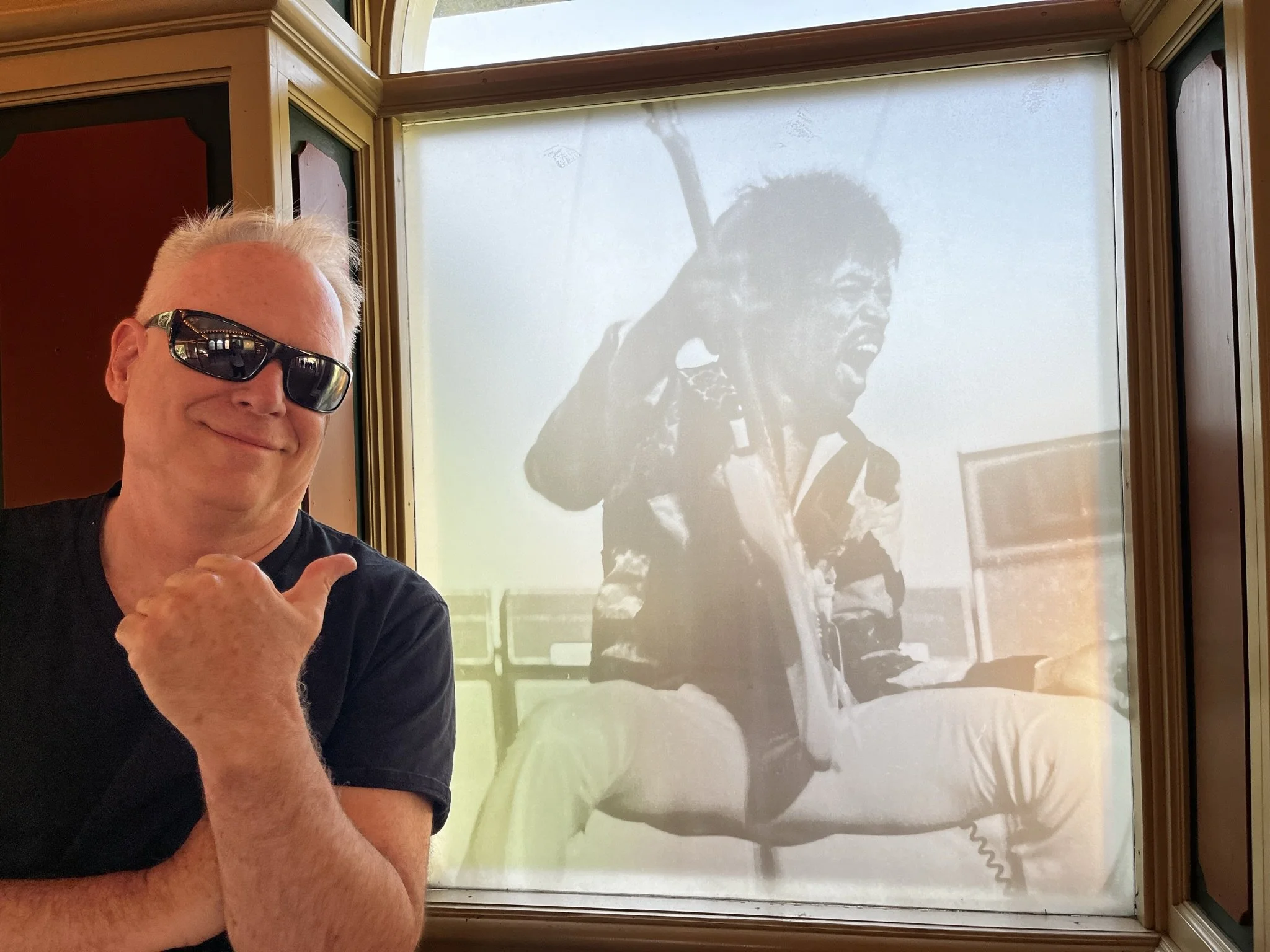 Kelly next to a picture of Jimi Hendrix taken at the show he attended on August 31, 1970 at Gröna Lund