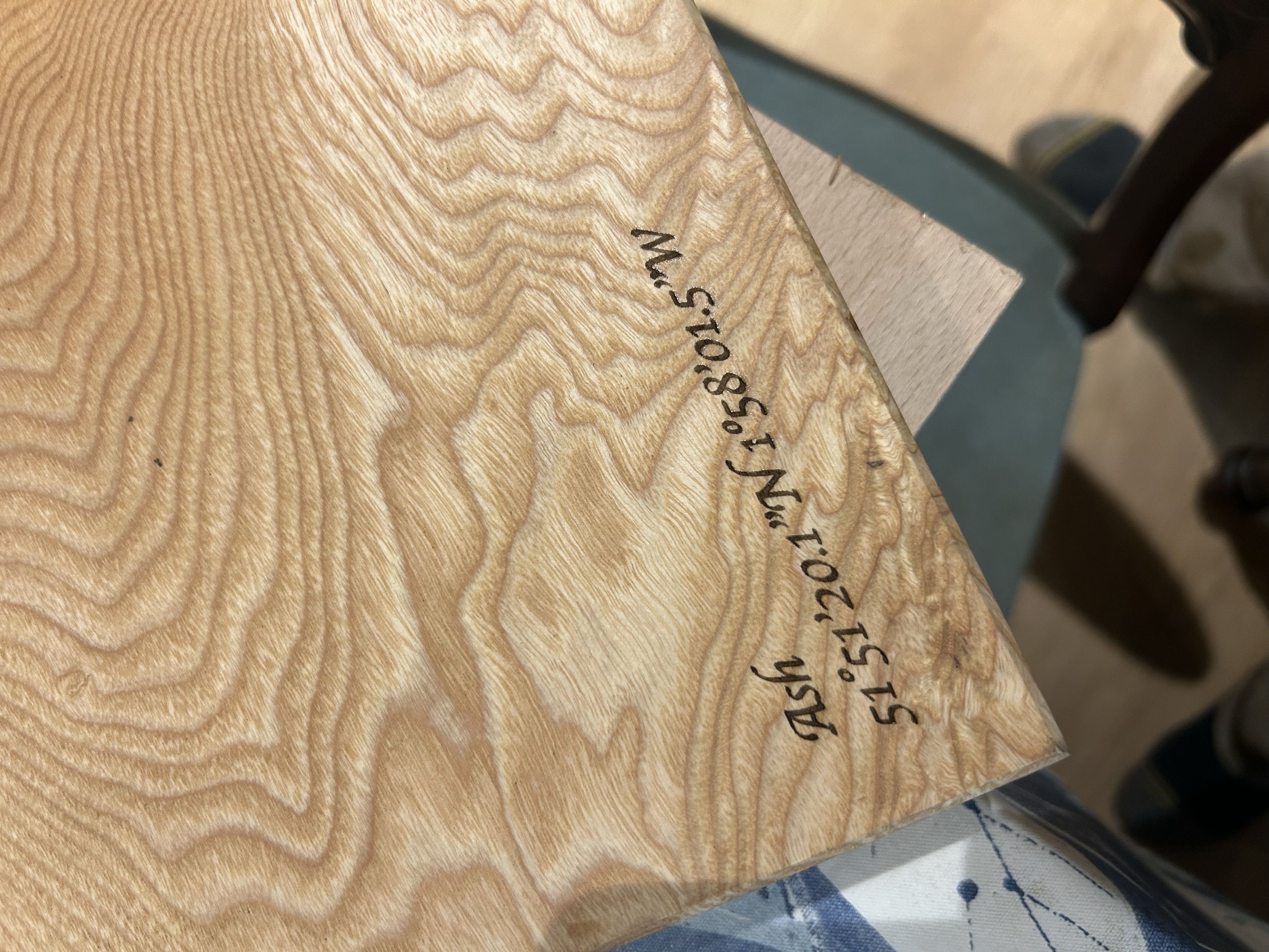 Close-up view of a wooden surface with measurements written on it in black ink, showing a radius of 5 1/2 inches and a diameter of 15 15/16 inches.