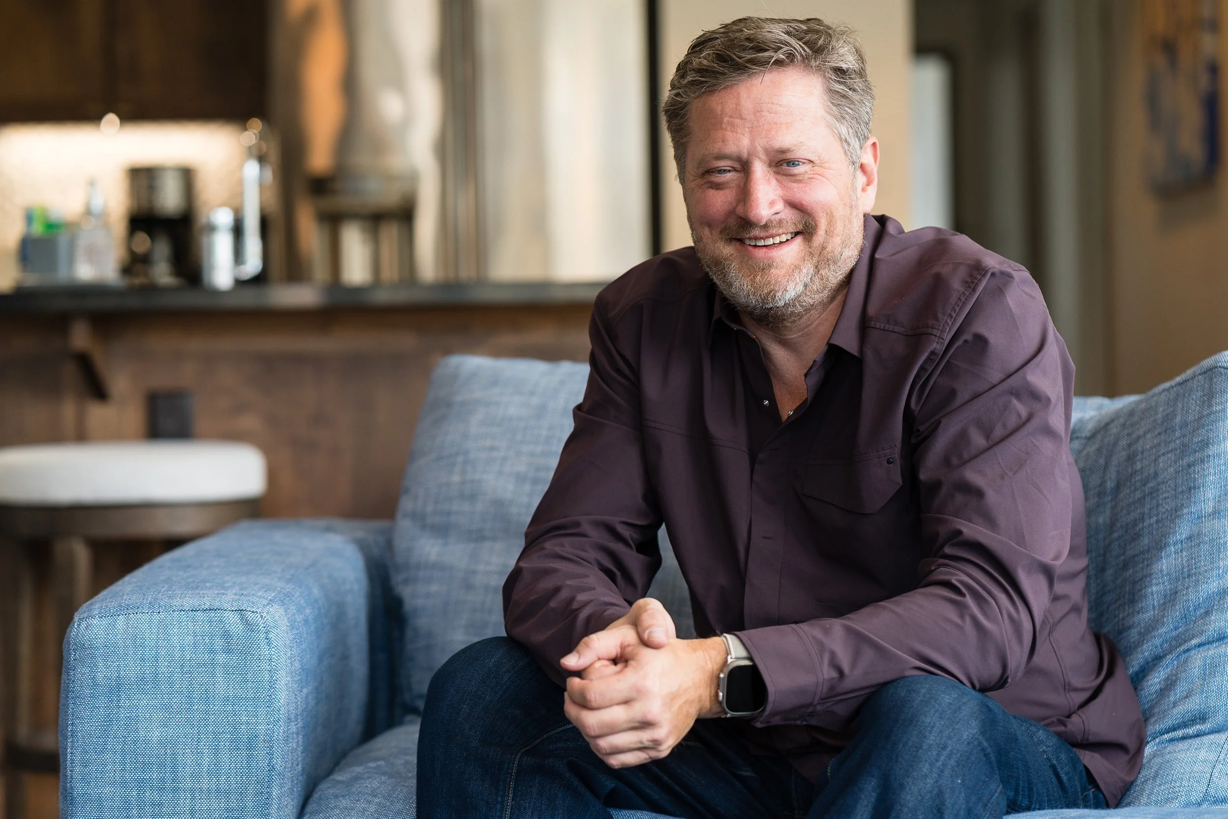 Garth Yettick, founder and owner of Luxart Property Management, sitting on blue sofa