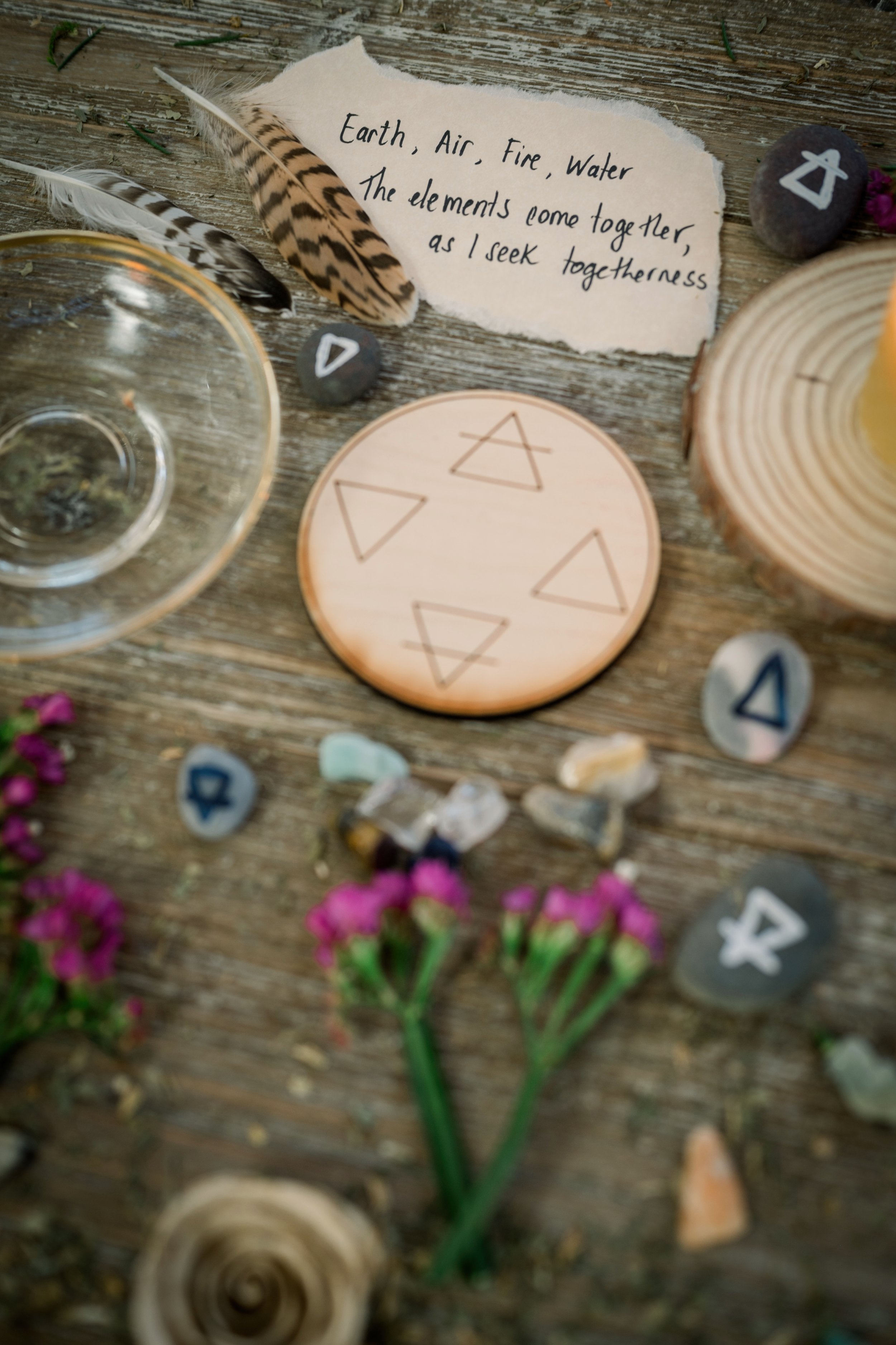 Wooden Altar with elemental symbols, feathers, crystals, and herbs evoking Earth, Air, Fire and Water energies in ritual harmony