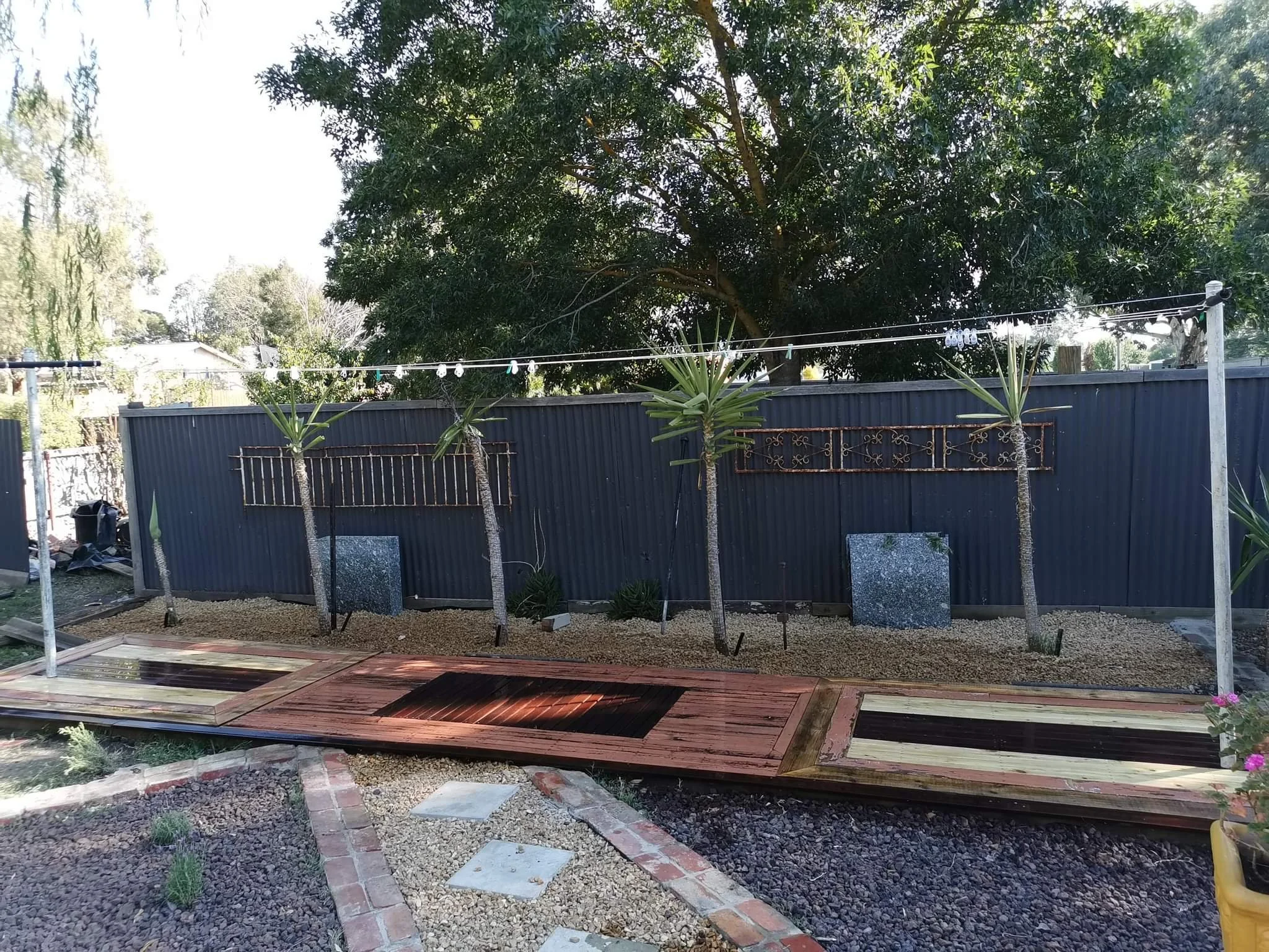 Old floorboards and doors turned into a outdoor decking for the washing line. Creative ideas to give this old 50s home a matching look for their outdoor oasis. Lower Blue Mountains carpentry.  