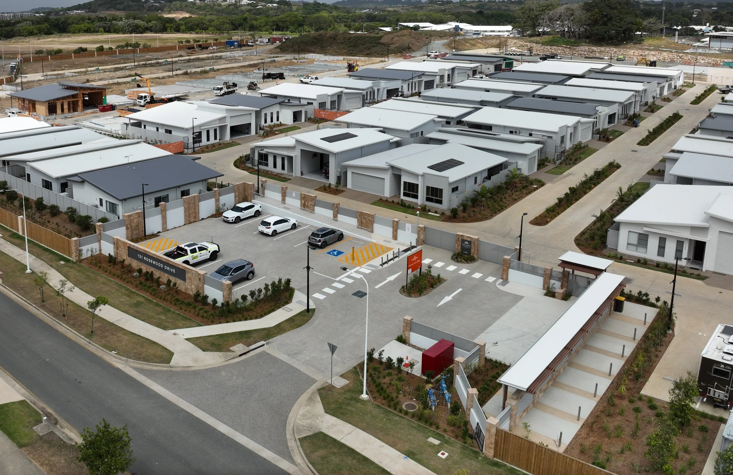 Drone image looking down on urban development of car parking, roads, street pavement and homes