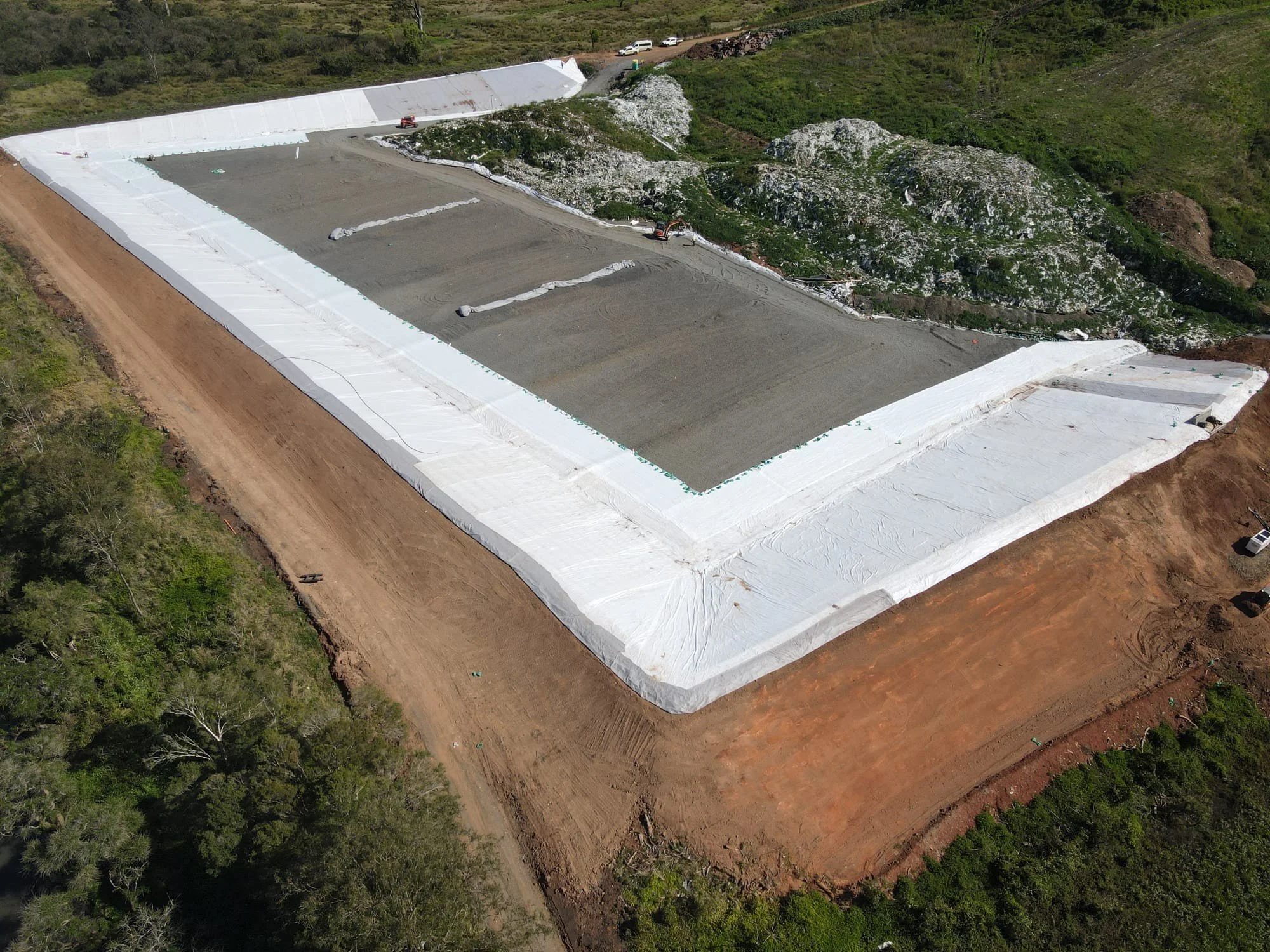 Drone image looking down on large landscape with embankment liner construction
