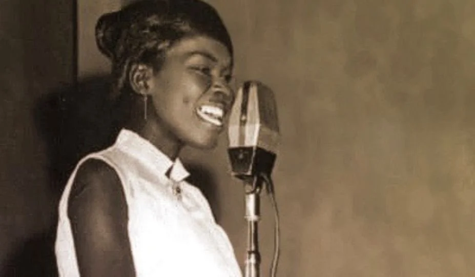 Hortense Ellis performing live at a microphone, pioneering female voice in Jamaican reggae and rocksteady