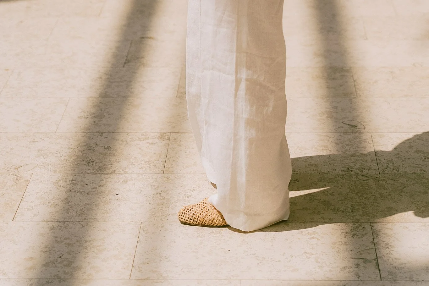 Részletkép személyes márka fotózáshoz, laza elegancia, fehér lenvászon nadrág, mészkő burkolat.