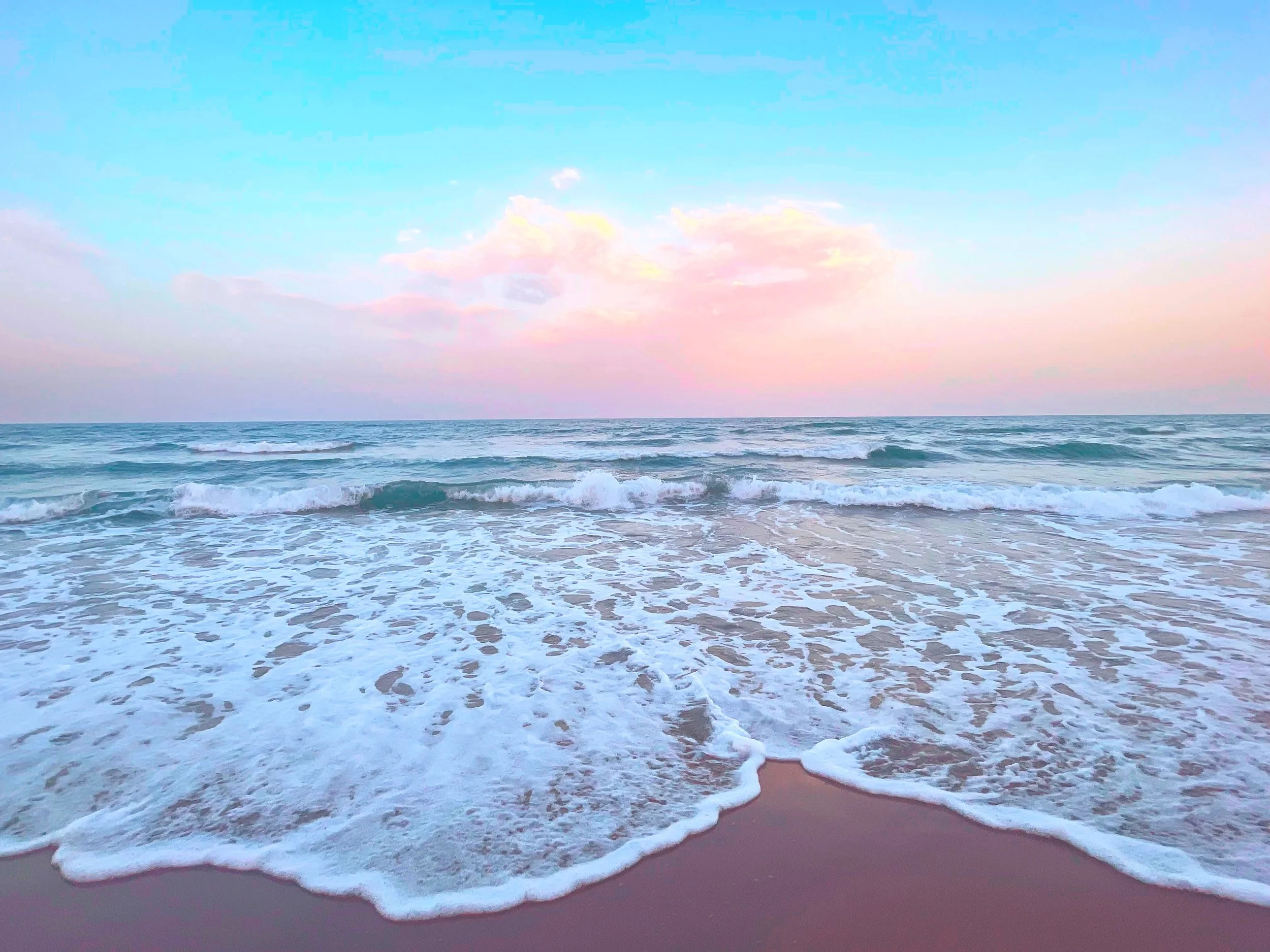 Plage avec des vagues douces, ciel pastel avec nuages roses et bleus, horizon calme.