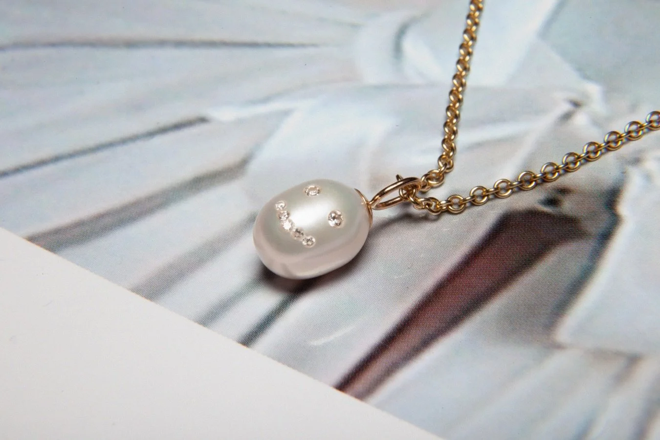 Fun bespoke commission - Freshwater pearl smiley pendant,
18ct gold bail and diamonds. 

For something similar get it touch.