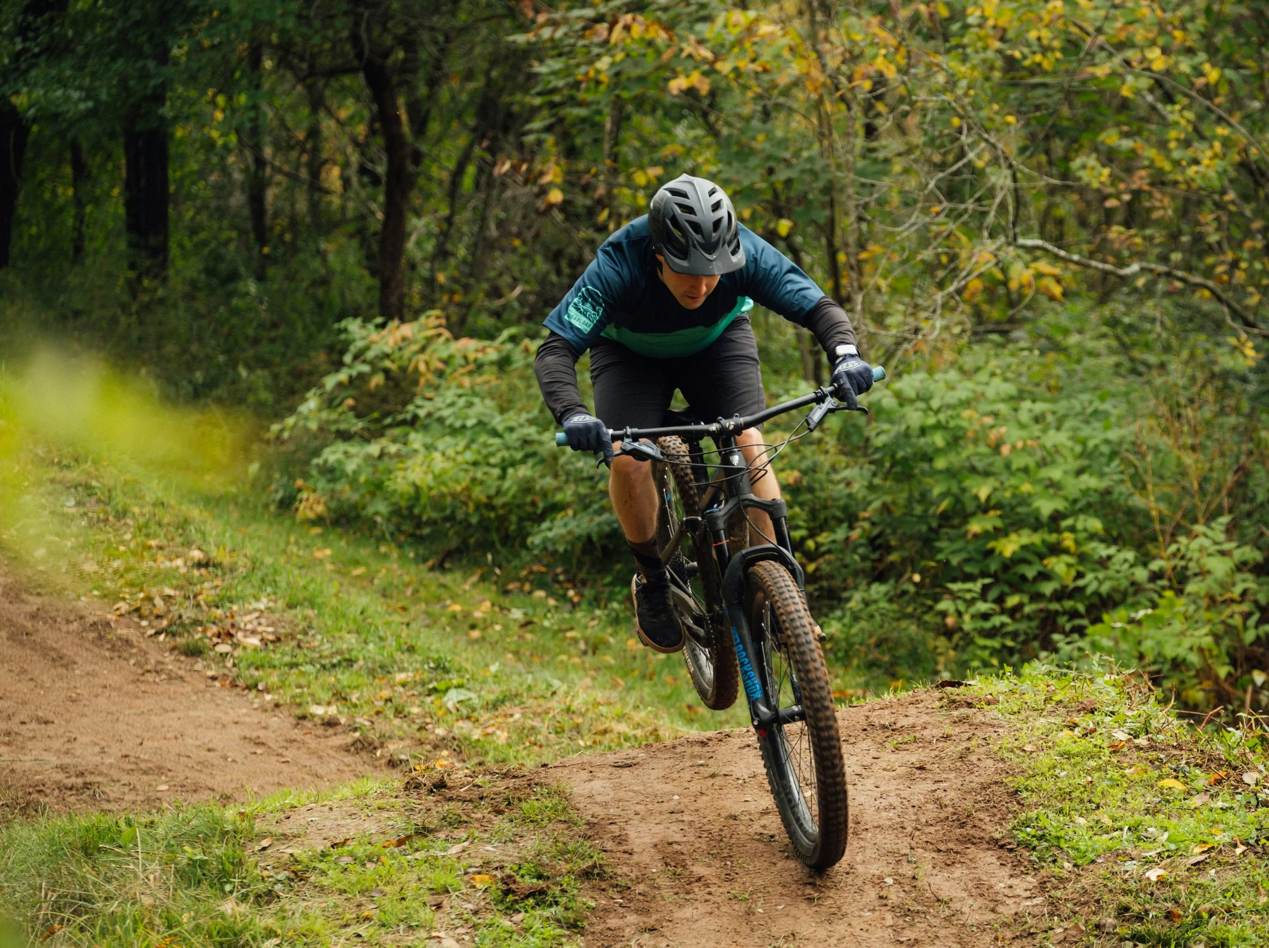 man riding mountain bike through woods