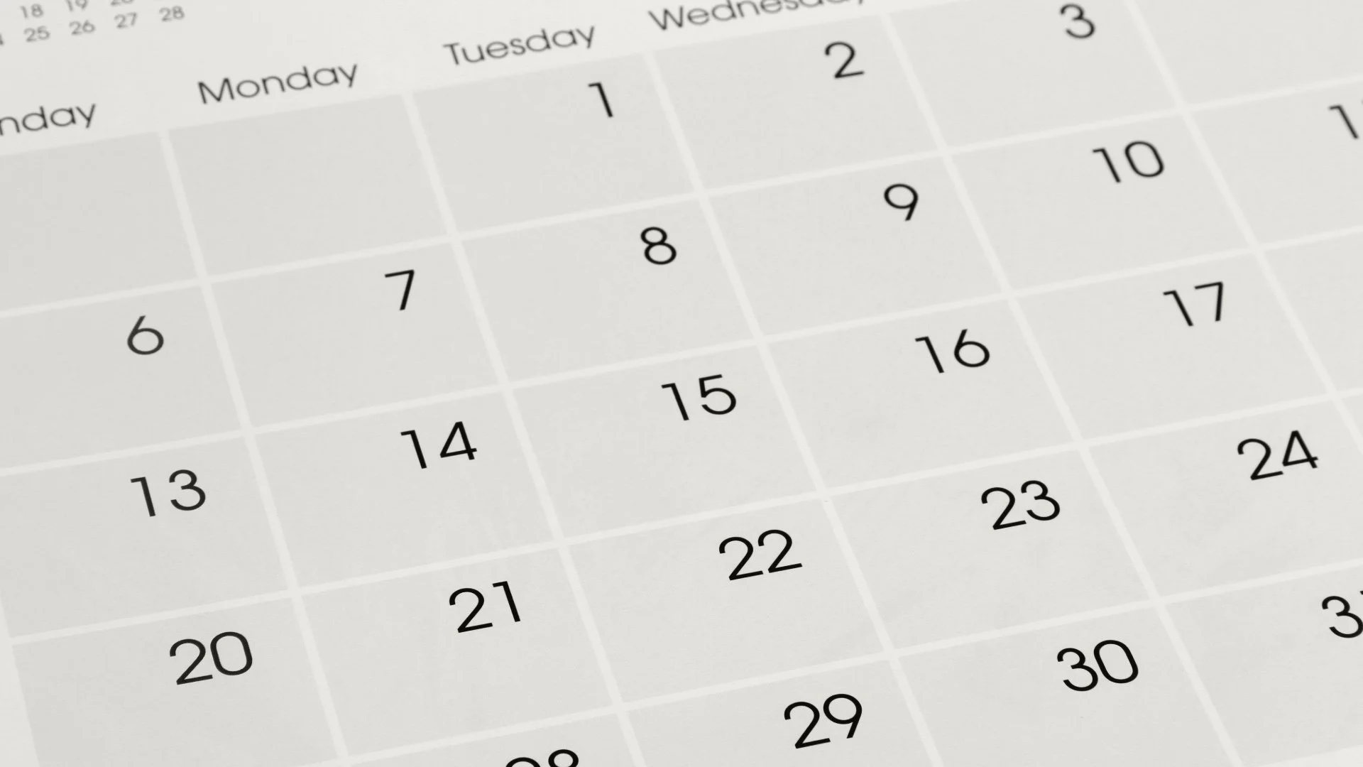 A close-up view of a printed calendar, showing the days of the month and days of the week, with the focus on the middle section.