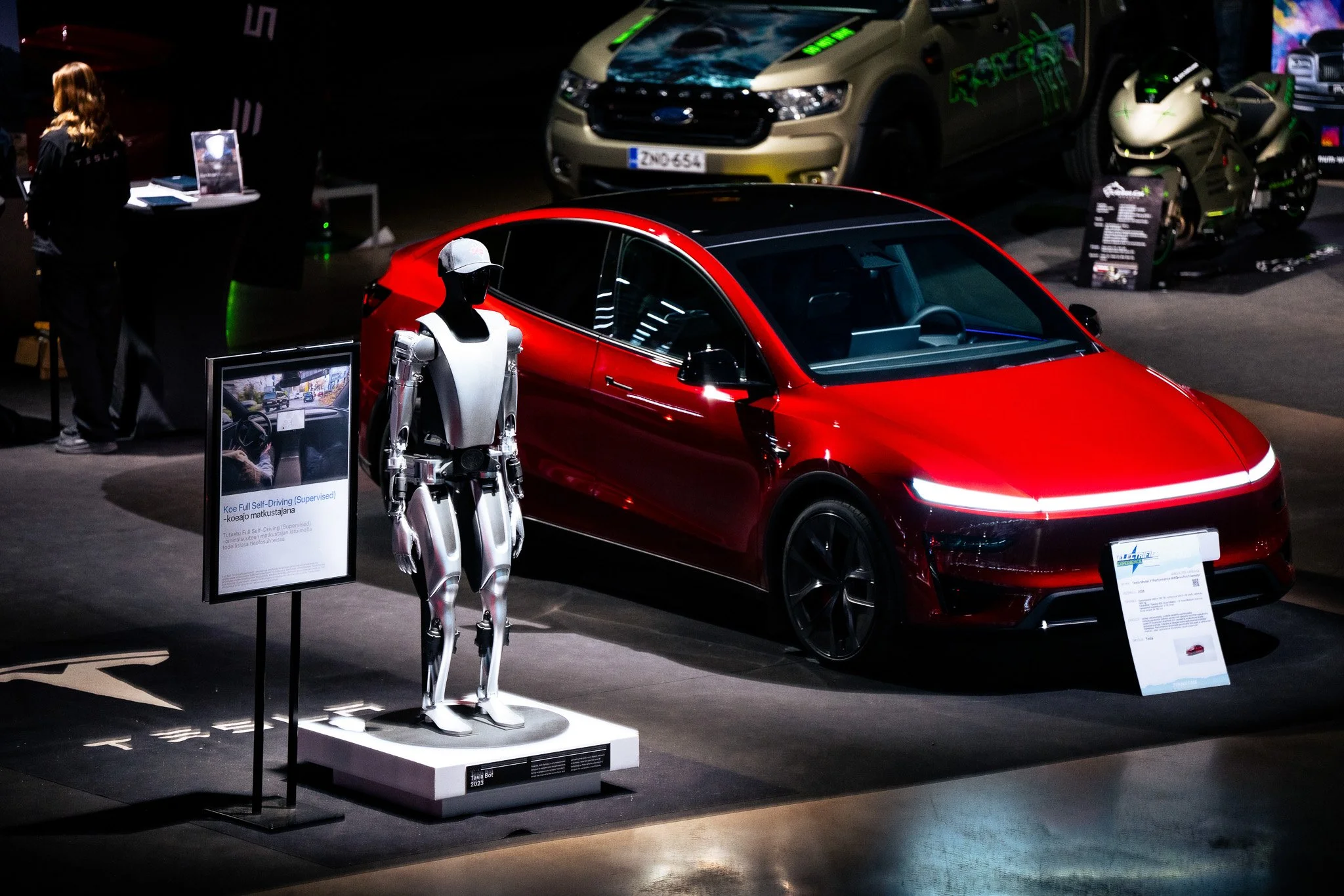 Värikäs urheiluauto uudella ja innovatiivisella muotoilulla, esillä sisätiloissa autoalan tapahtumassa.