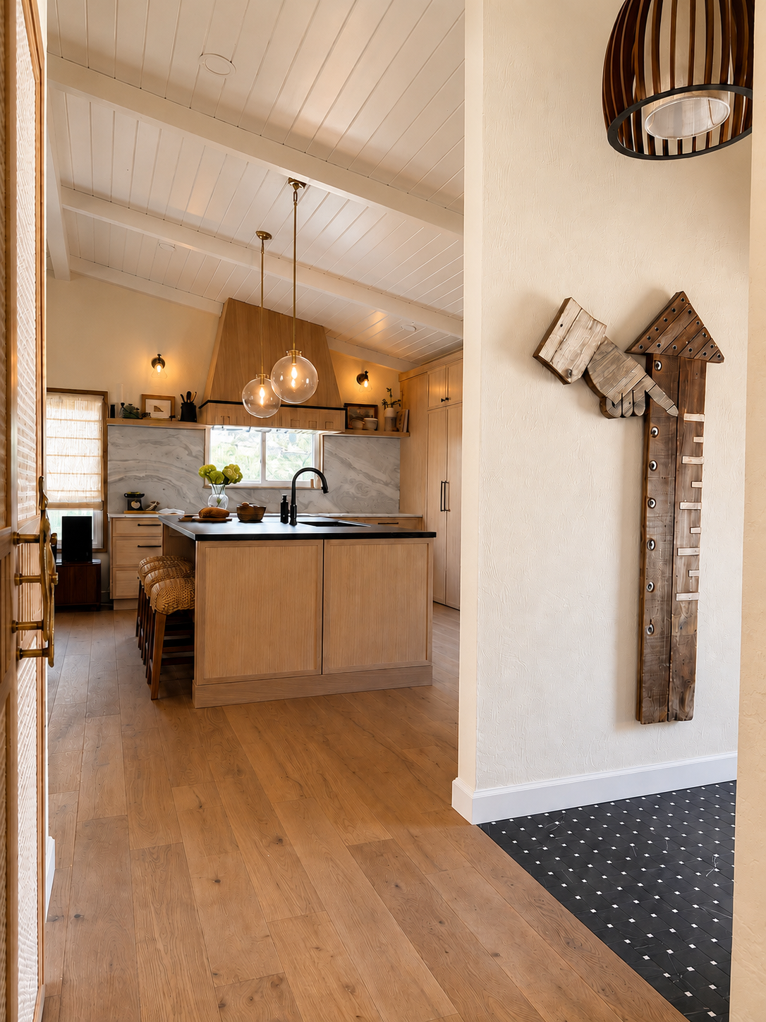 A cozy kitchen with wooden cabinets, a breakfast bar with woven stools, pendant lights, a window above the sink, and a decorative wooden piece on the wall.
