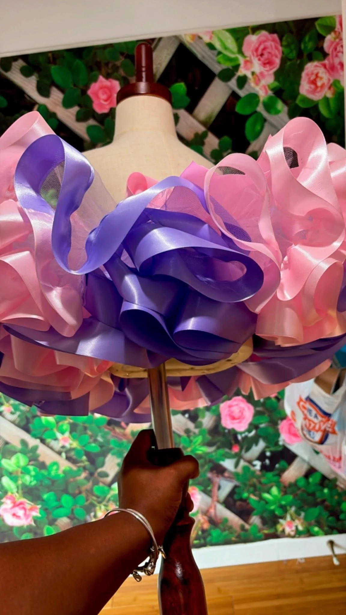Blue tutu with silver accents and a silver bow displayed on a mannequin against a leafy background.