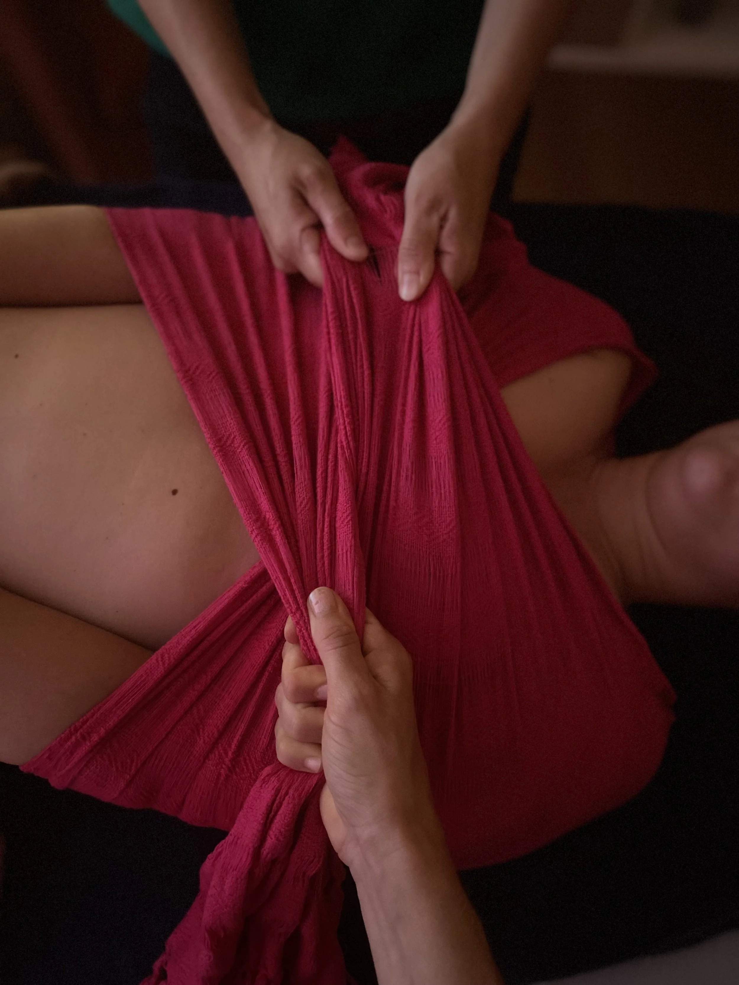 Une personne attrape un vêtement rouge avec ses mains.