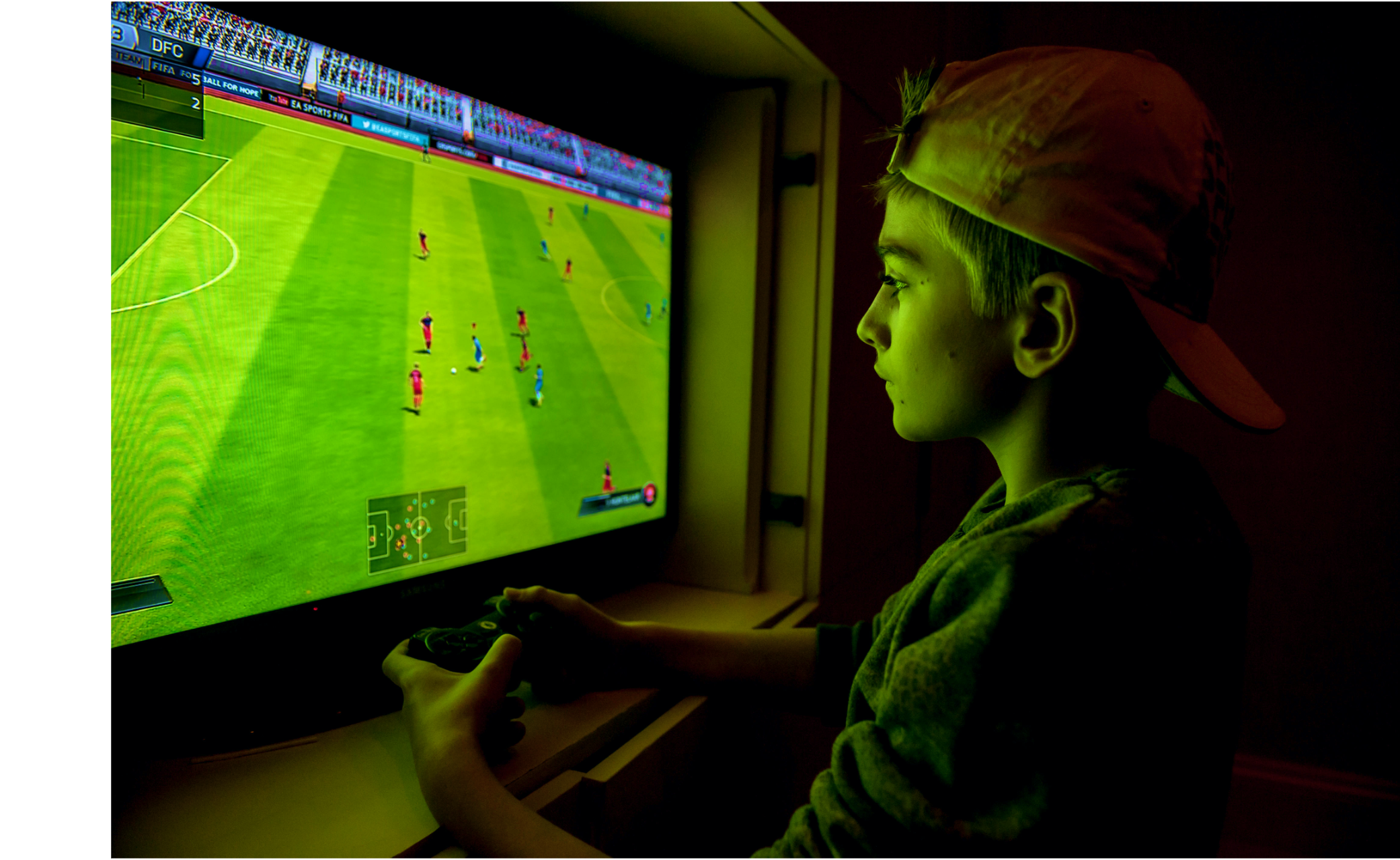 A young person absorbed in a sports video game