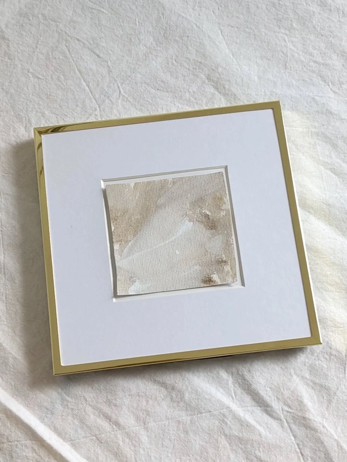 A small painting with soft hazel brown and cream tones, framed in elegant gold. This piece blends subtle brushstrokes and gentle color transitions, bringing warmth and calm to any space. A beautiful mini painting that adds a serene, organic touch to 