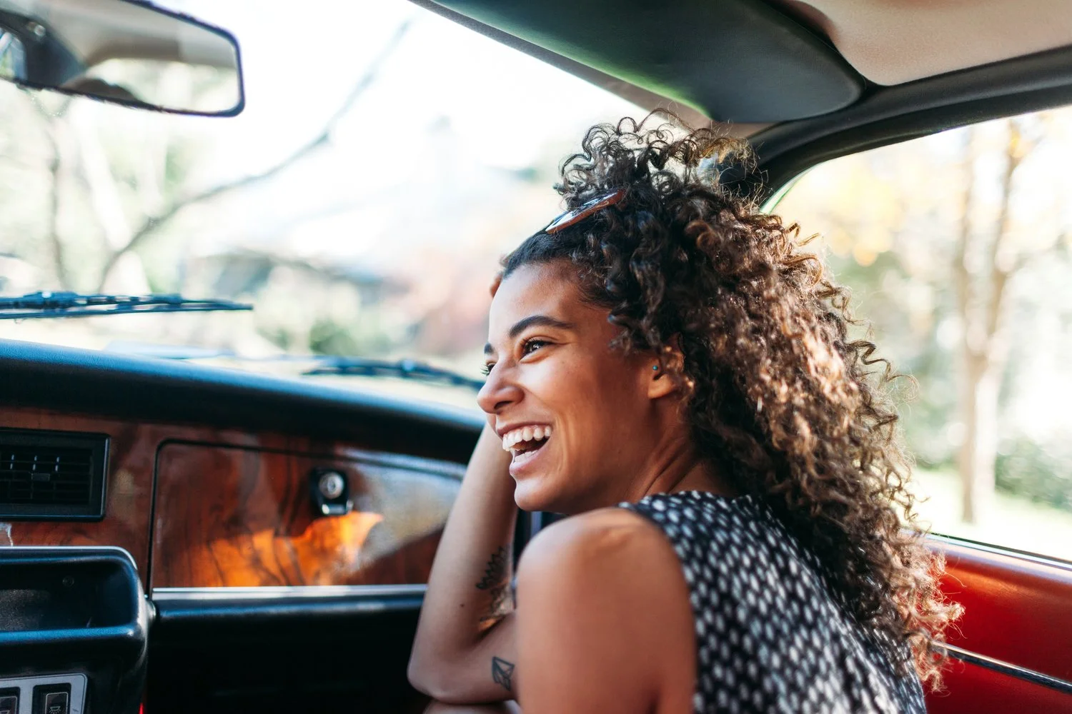 Woman smiling while sitting in a car
