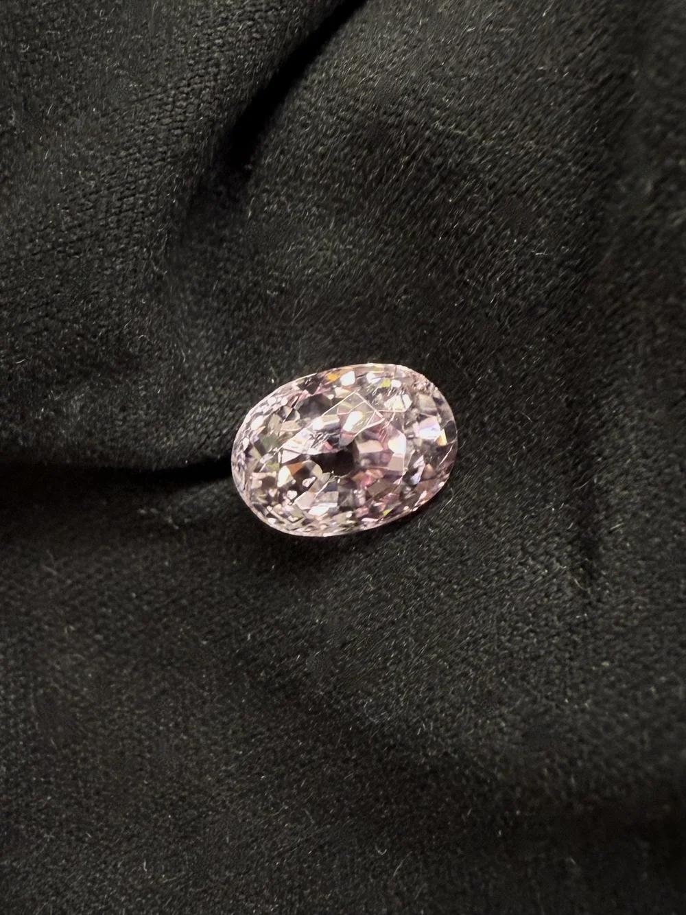 A sweet and petite pastel pink sapphire oval with antique faceting